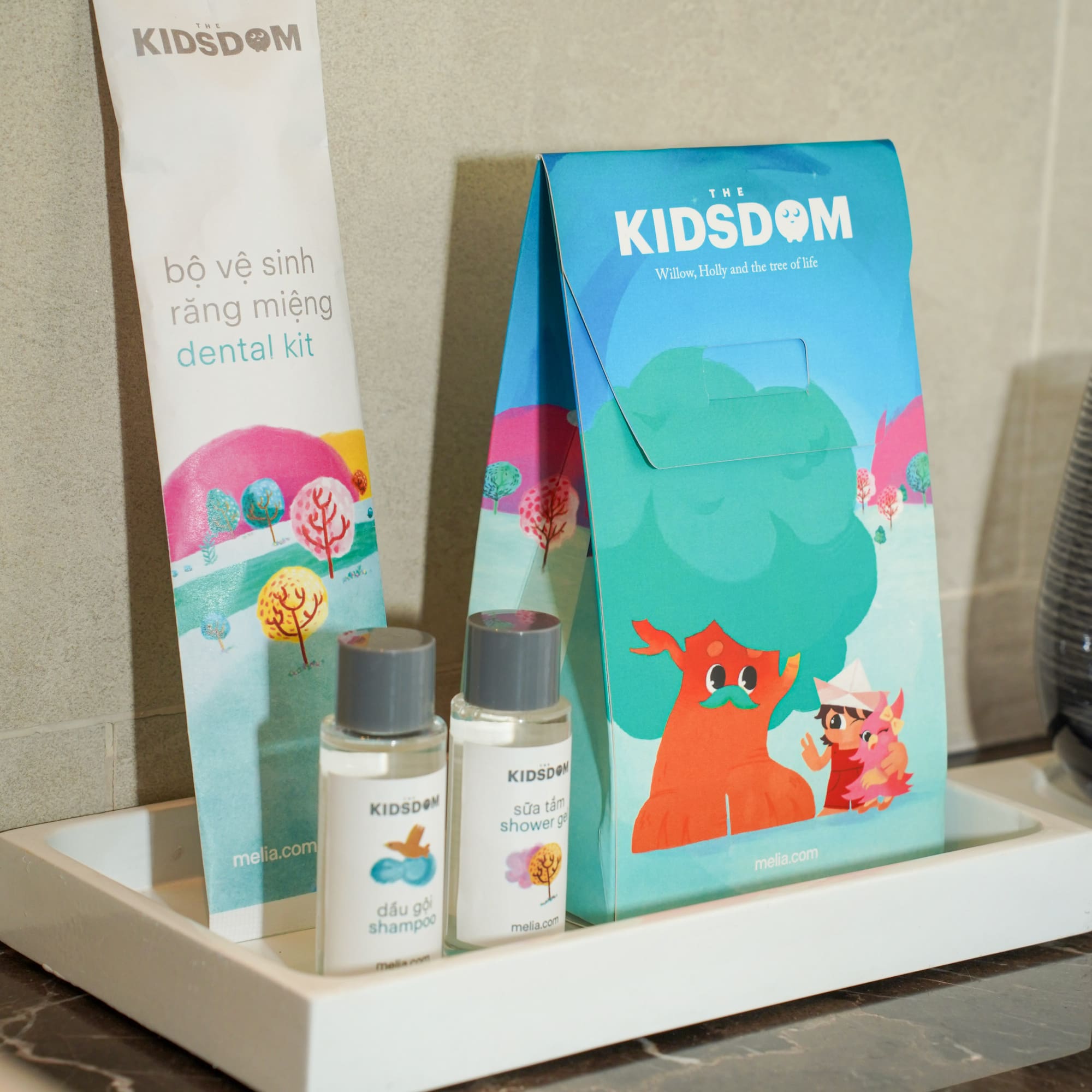 a small white tray with a bag and bottles of shampoo on it