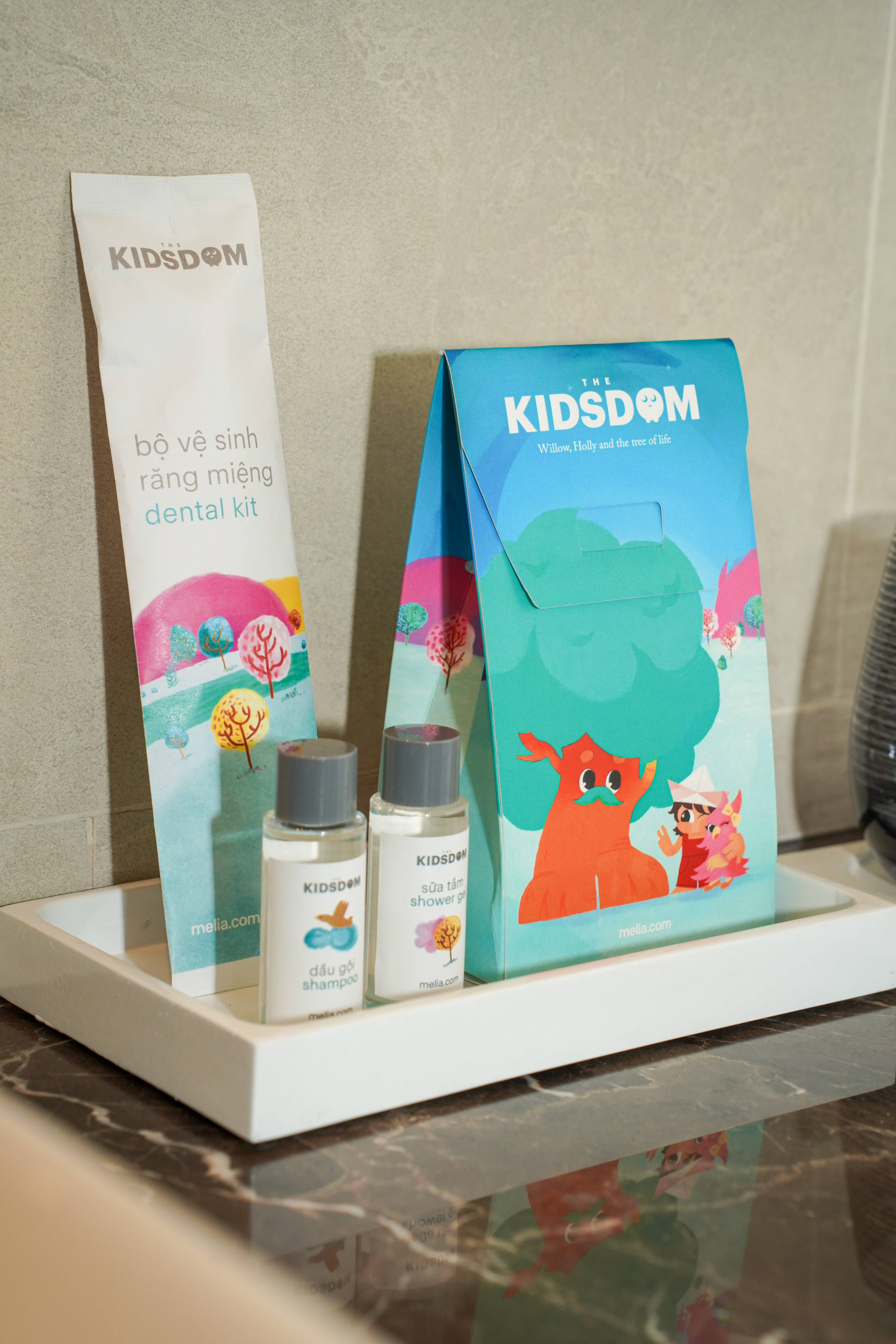 a small white tray with a bag and bottles of shampoo on it