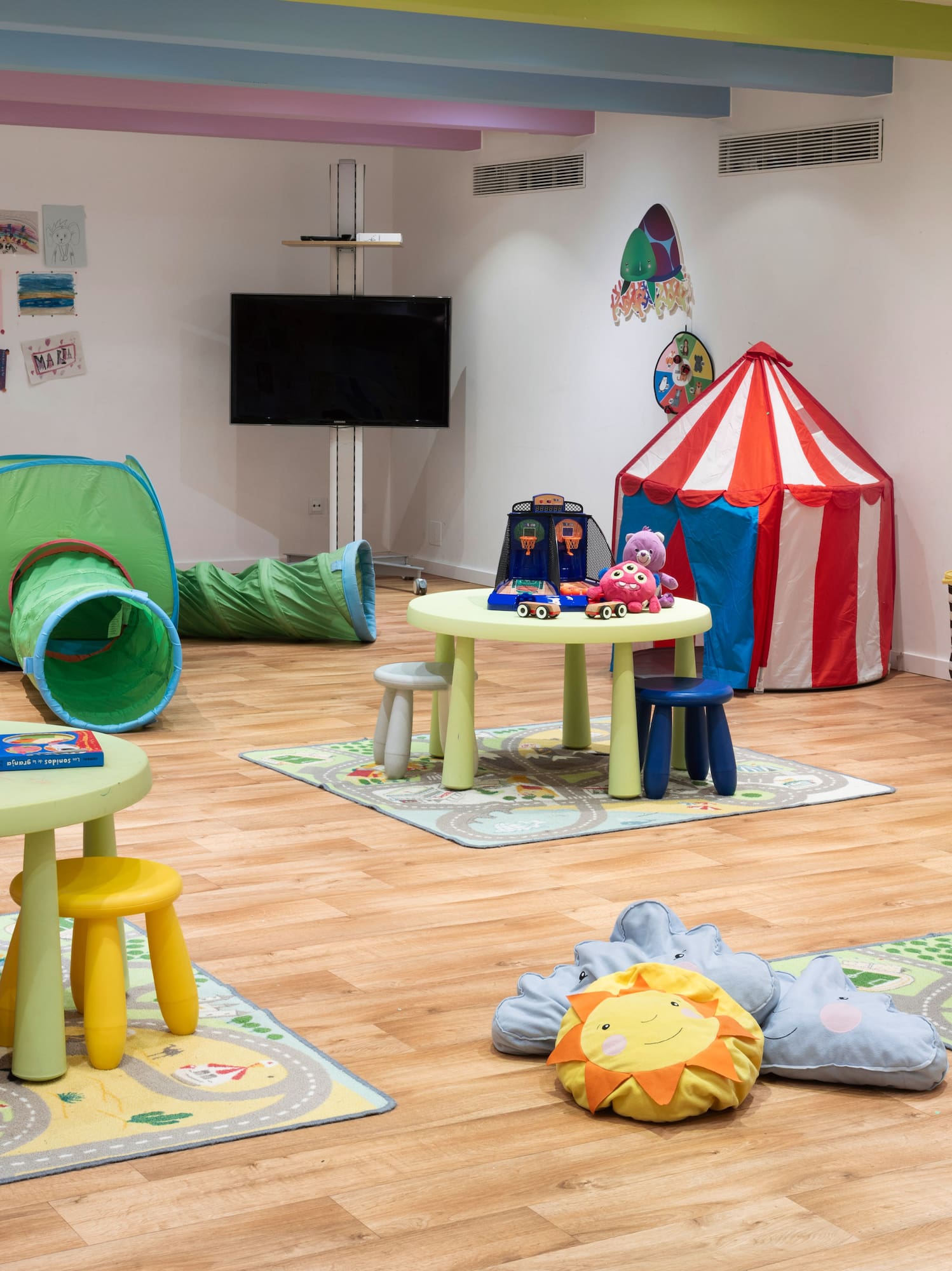 a room with a playroom with tables and toys