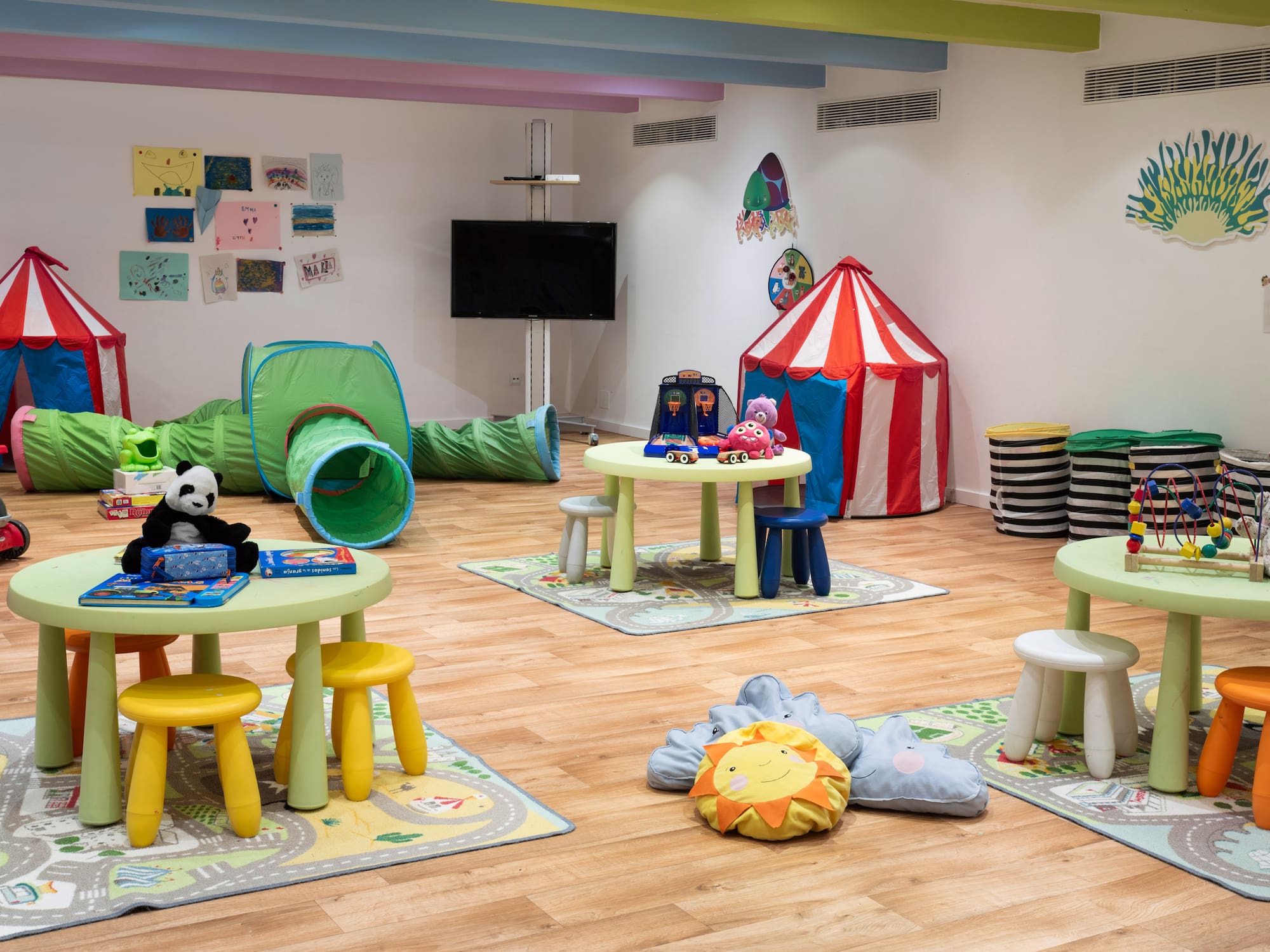 a room with a playroom with tables and toys