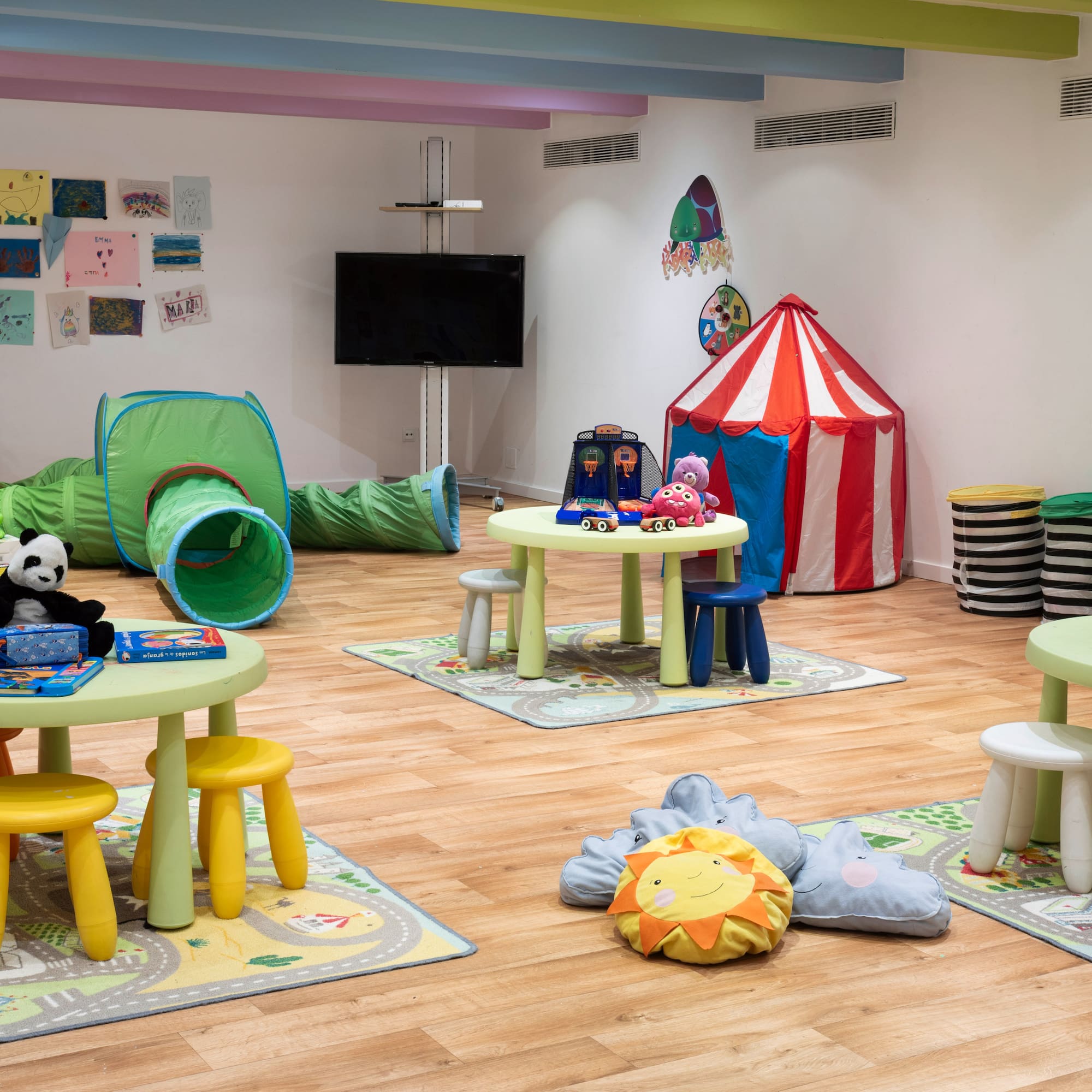 a room with a playroom with tables and toys