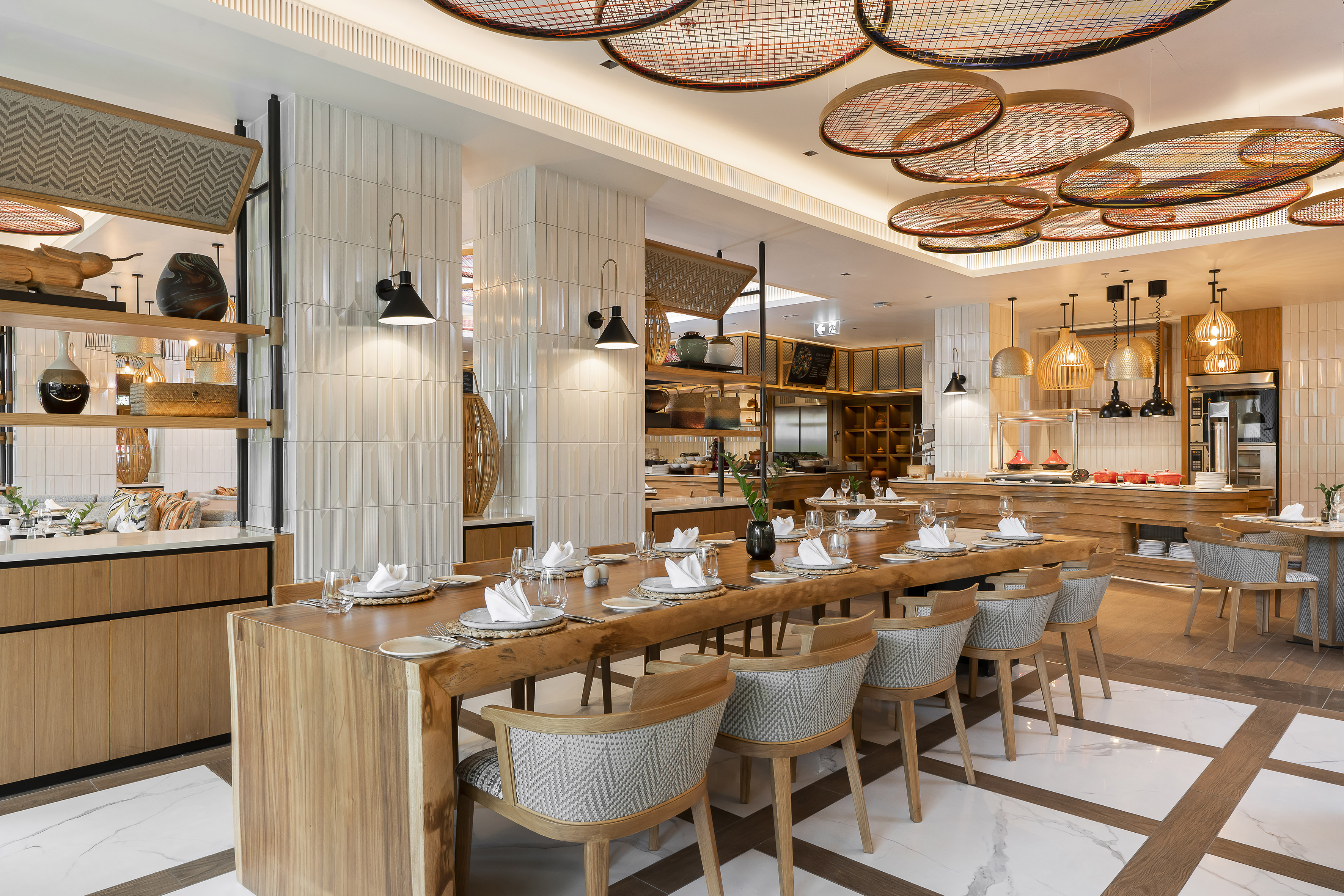 Modern hotel restaurant dining, long wooden table, unique ceiling decor.