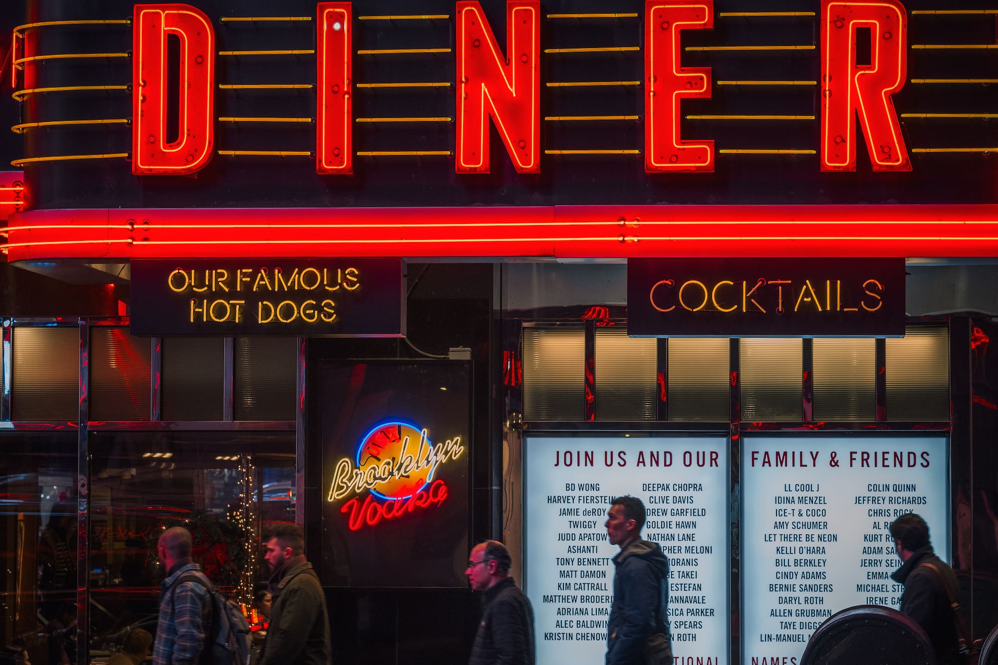 a group of people walking past a restaurant