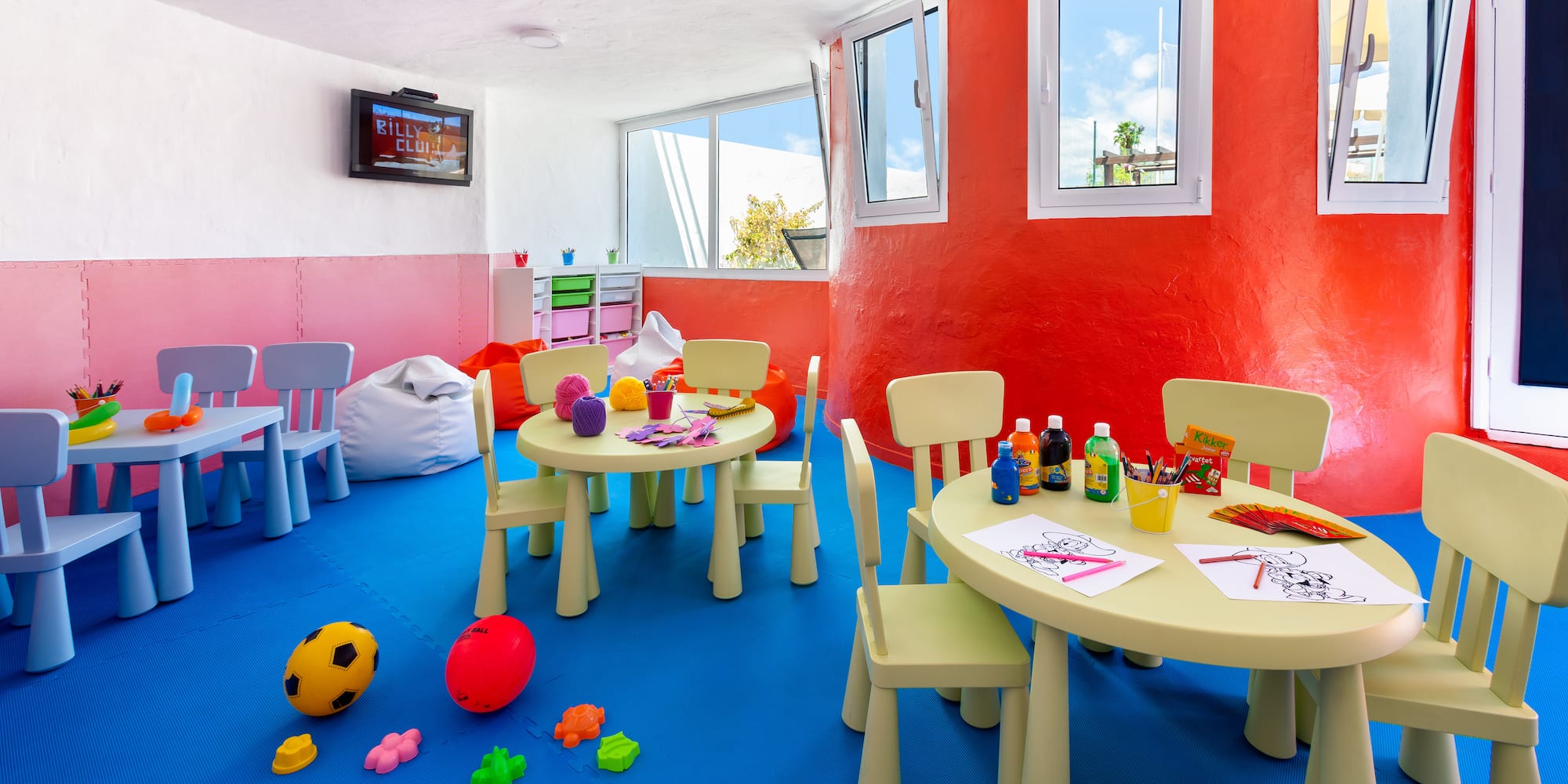 a room with a table and chairs and toys