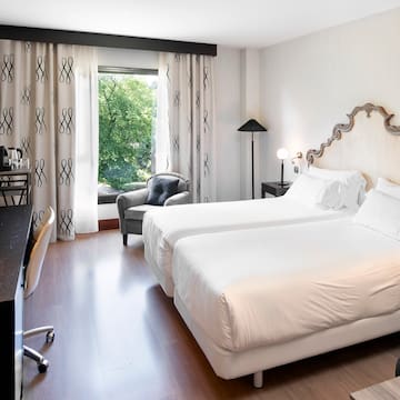 a room with two beds and a chair