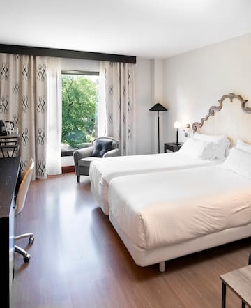 a room with two beds and a chair