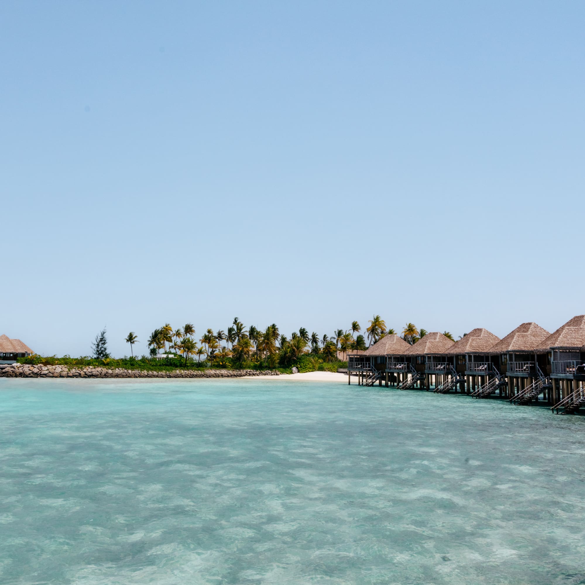a group of huts on stilts on a beach