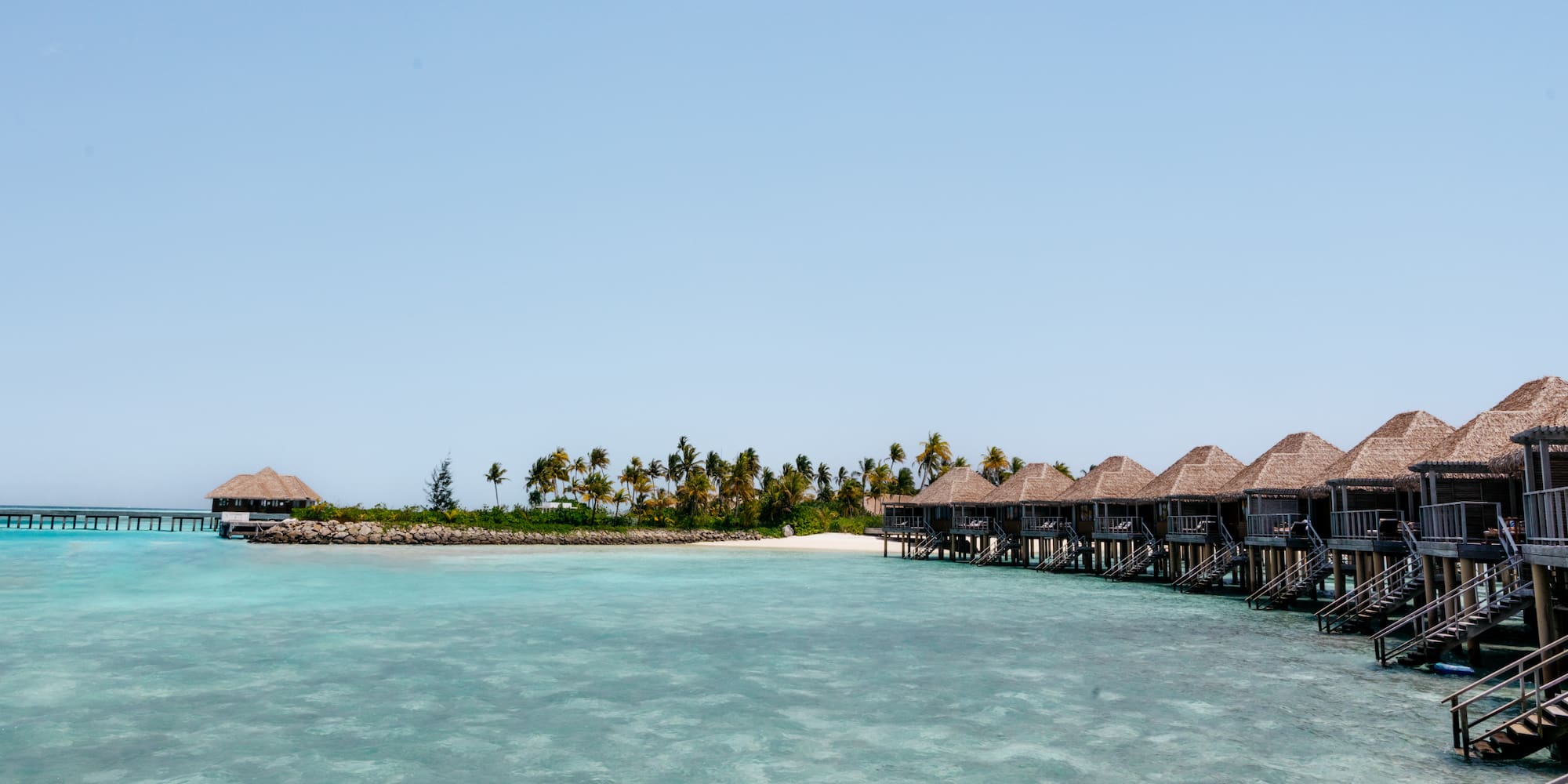 a group of huts on stilts on a beach