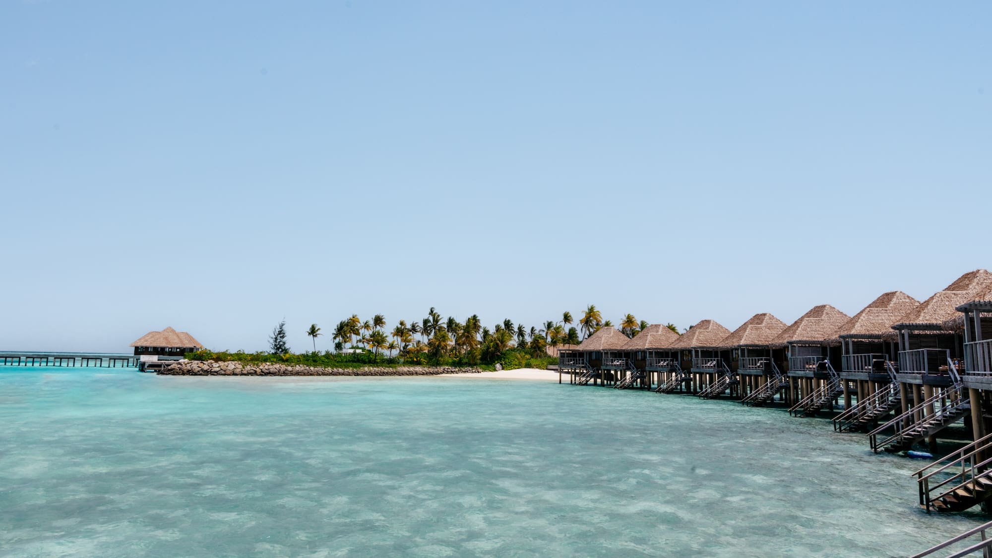 a group of huts on stilts on a beach