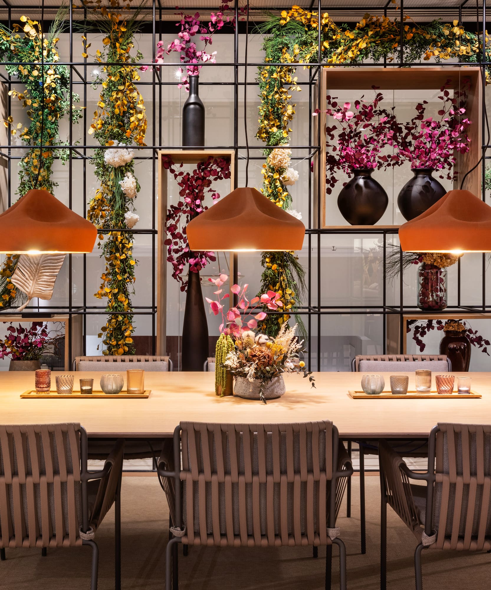 a table with chairs and a vase of flowers