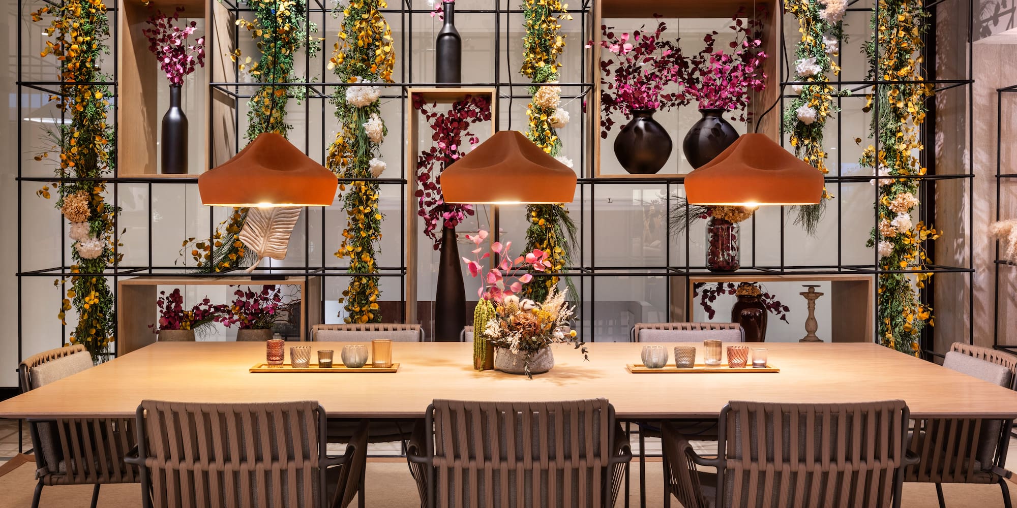 a table with chairs and a vase of flowers