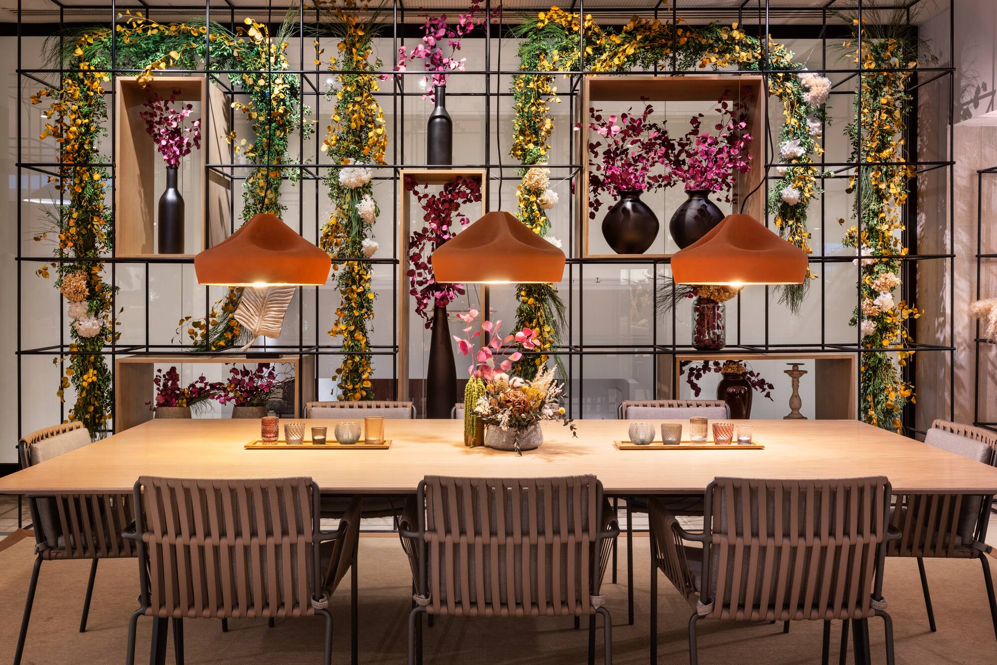 a table with chairs and a vase of flowers