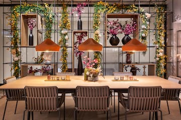 a table with chairs and a vase of flowers