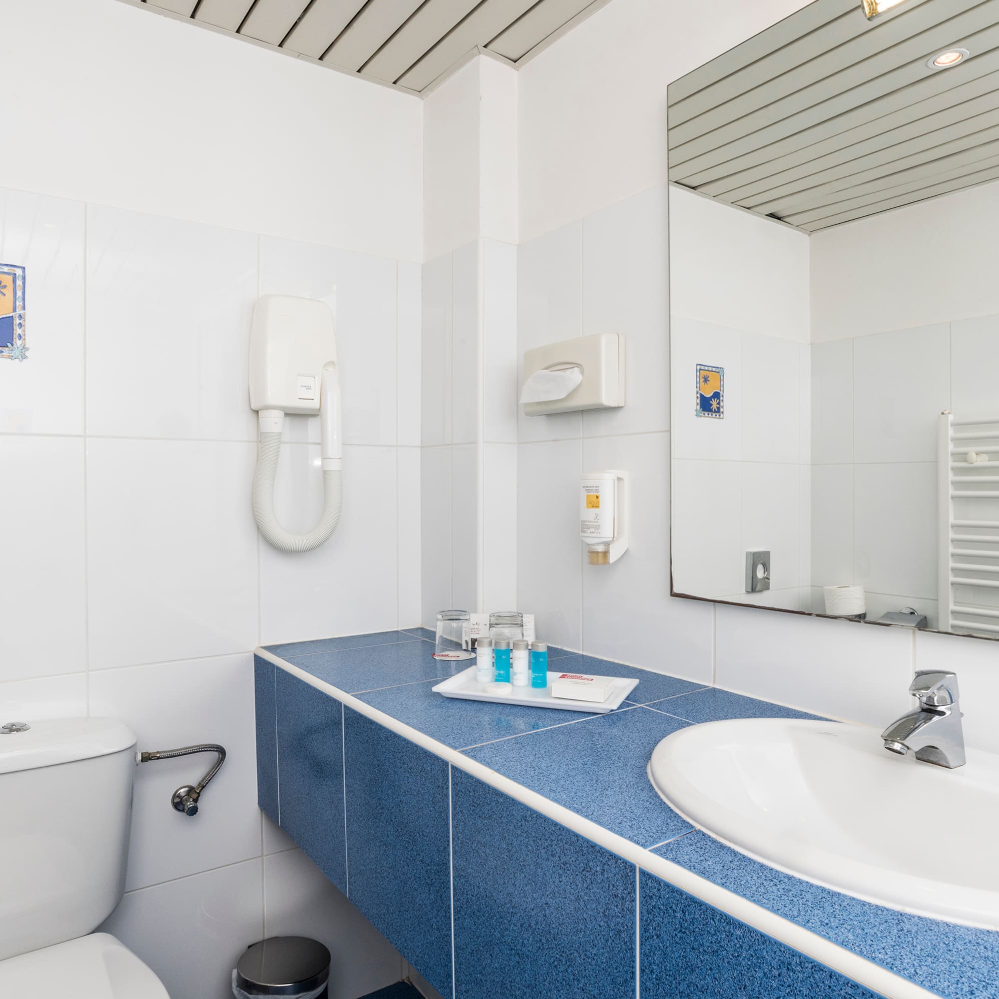 a bathroom with a blue countertop and a toilet