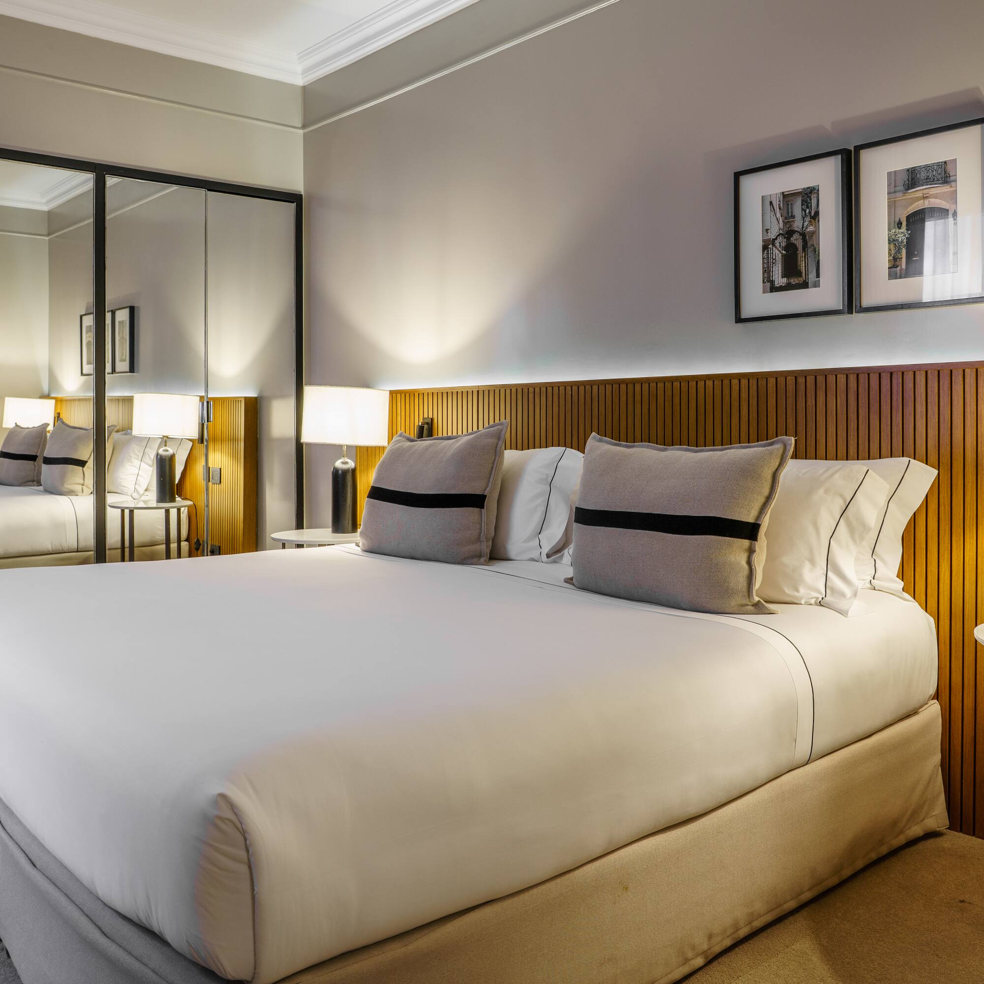 a bed with a mirror and lamps