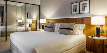 a bed with a mirror and lamps