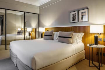 a bed with a mirror and lamps