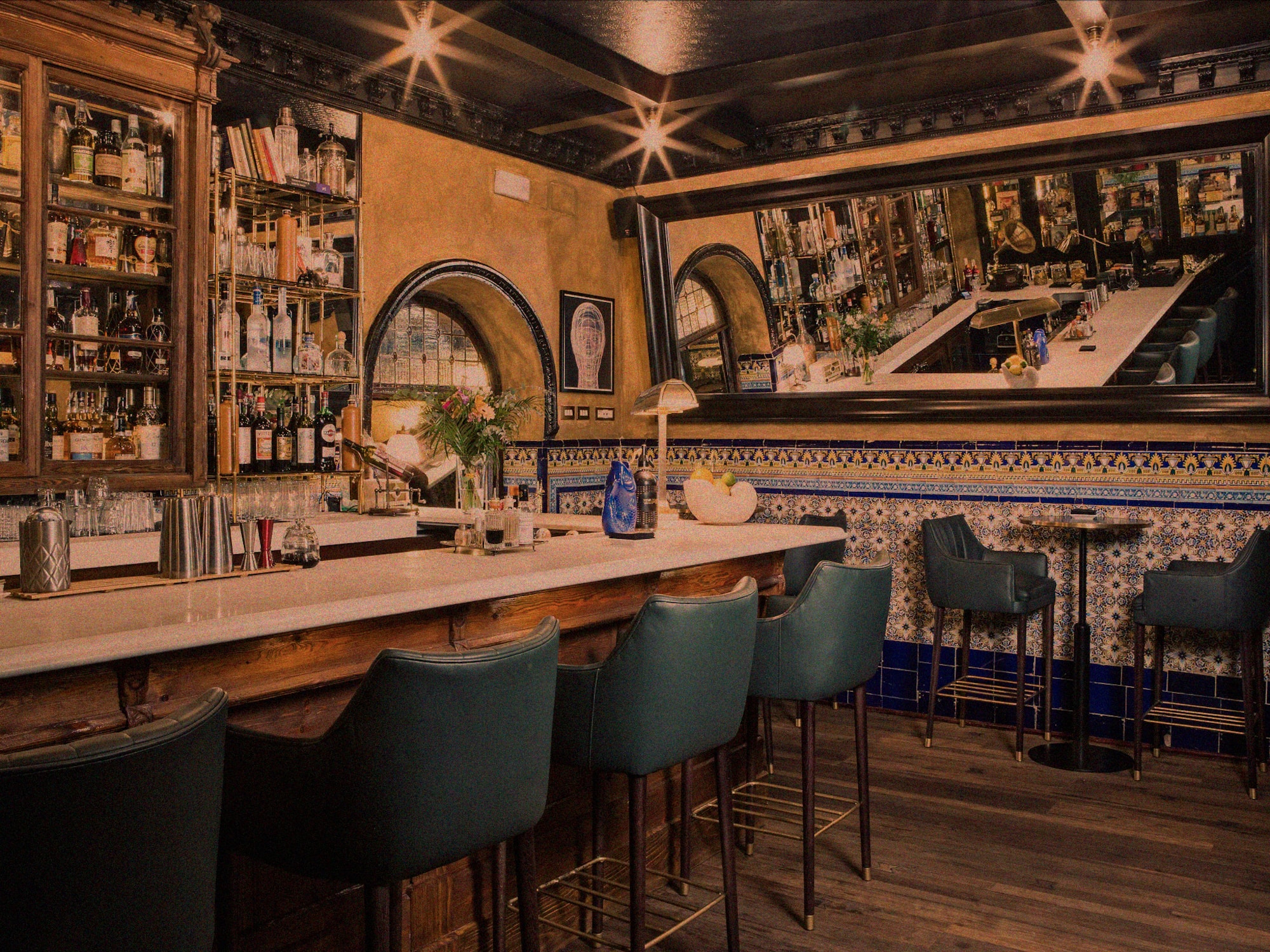 a bar with chairs and a mirror above it