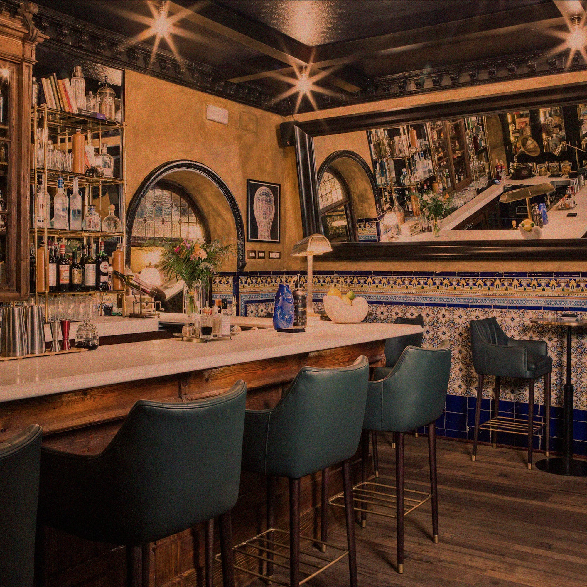 a bar with chairs and a mirror above it