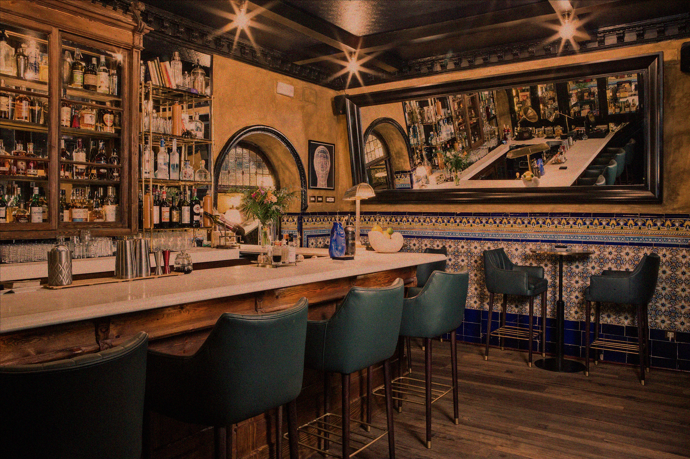 a bar with chairs and a mirror above it