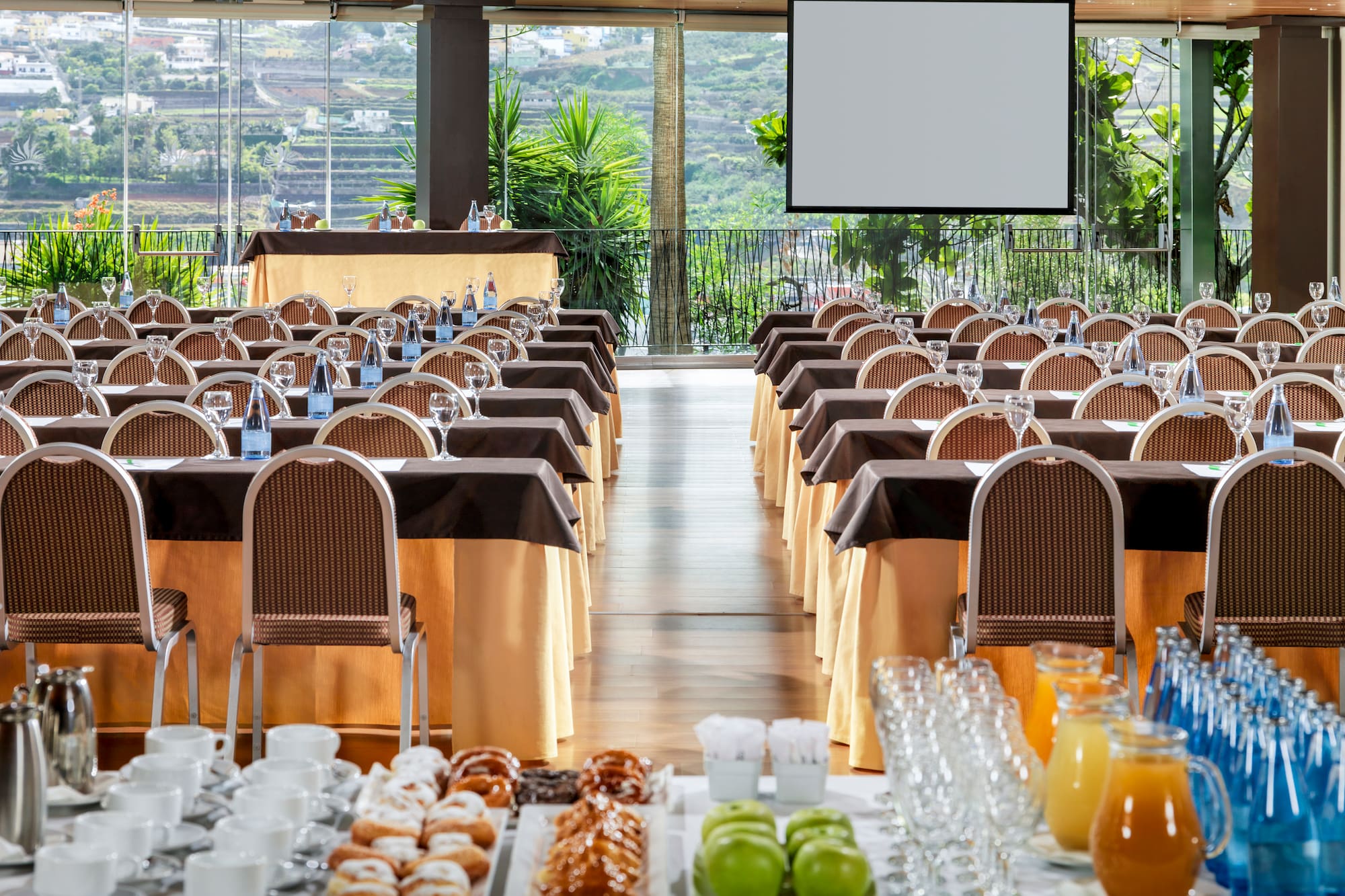 a room with tables and chairs and a screen