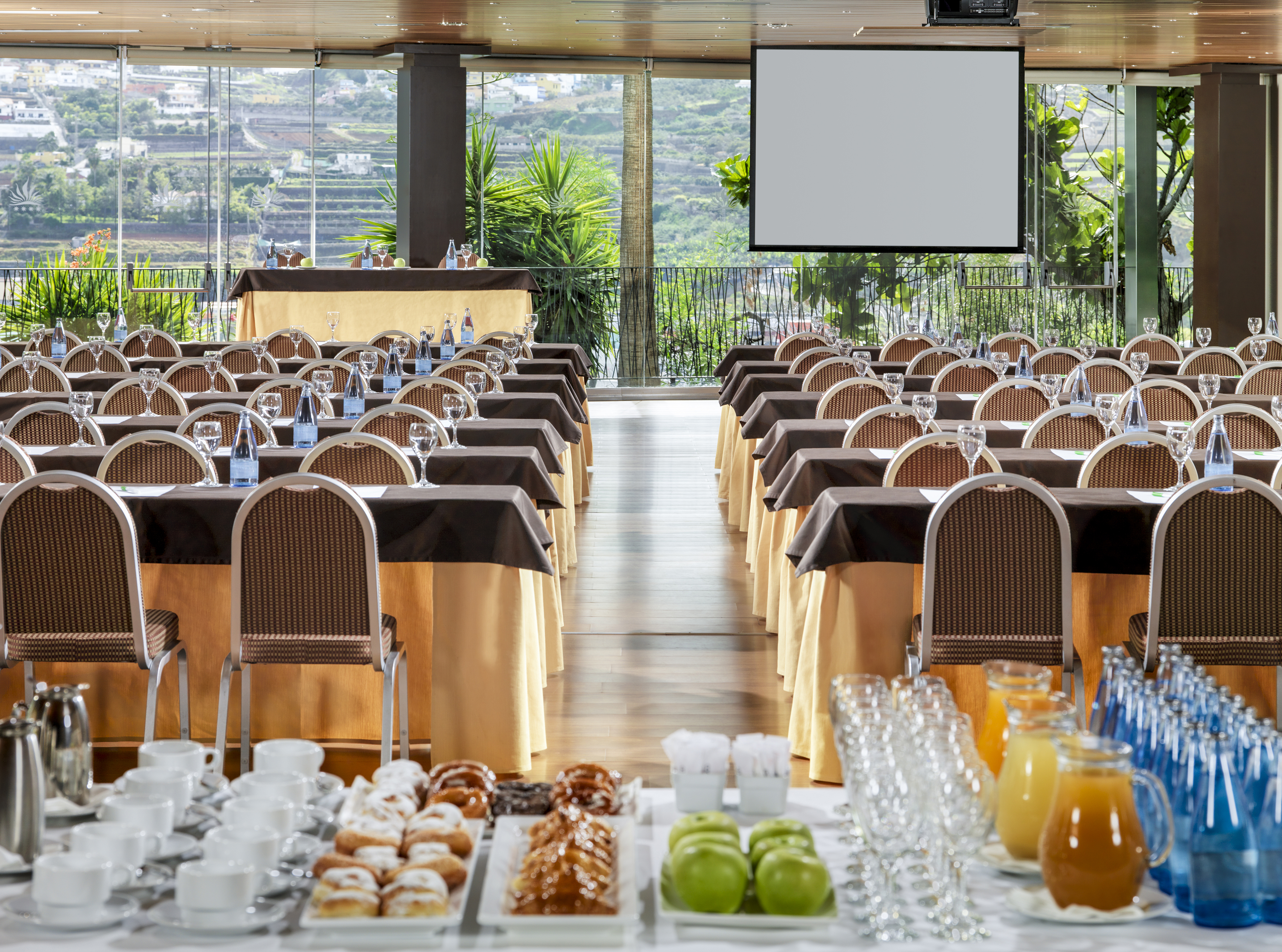 a room with tables and chairs and a screen