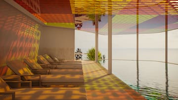 a pool with chairs and a view of the ocean