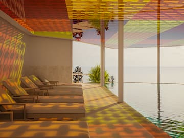 a pool with chairs and a view of the ocean