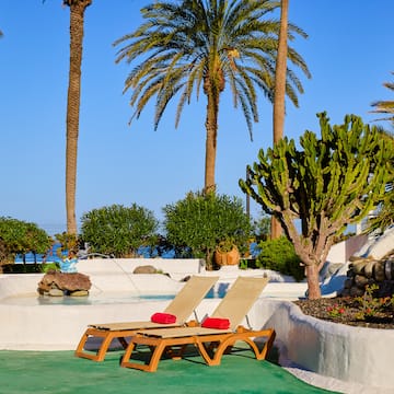 a lounge chairs by a pool