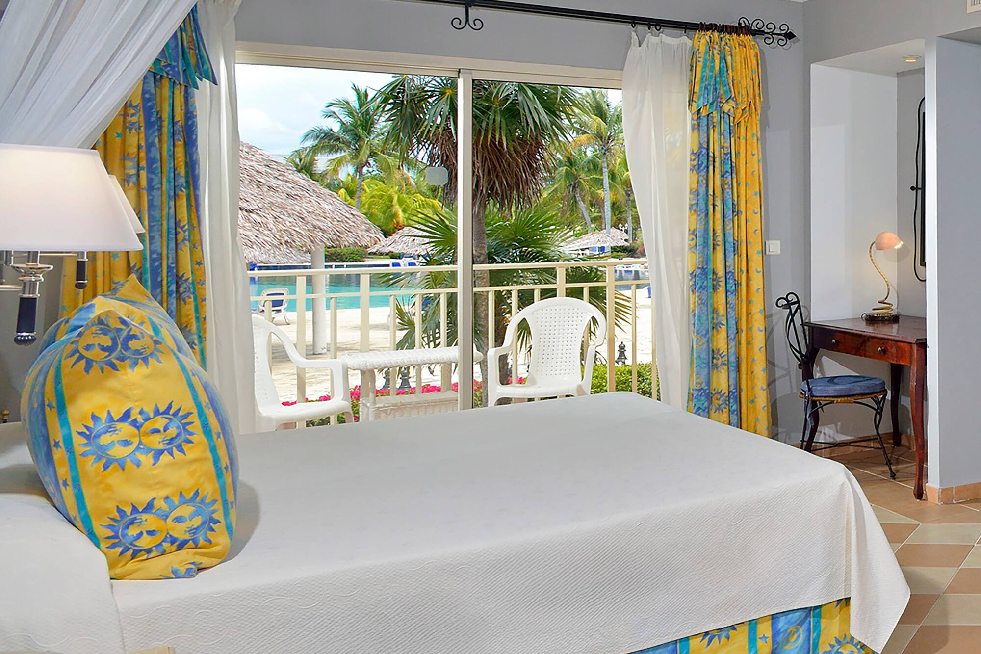 a room with a bed and a table and chairs