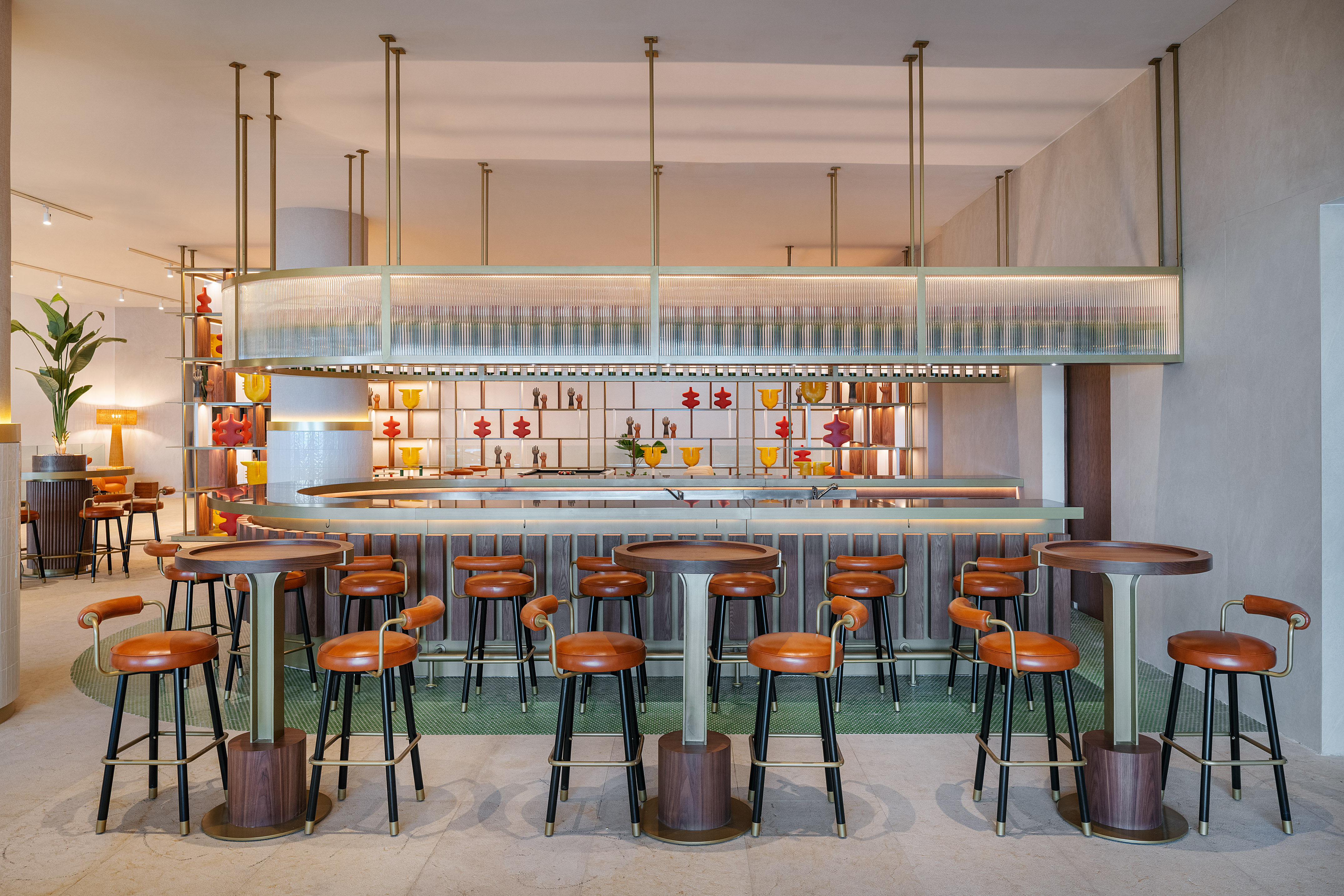 Modern bar with brown leather stools, colorful abstract decor, and elegant lighting.