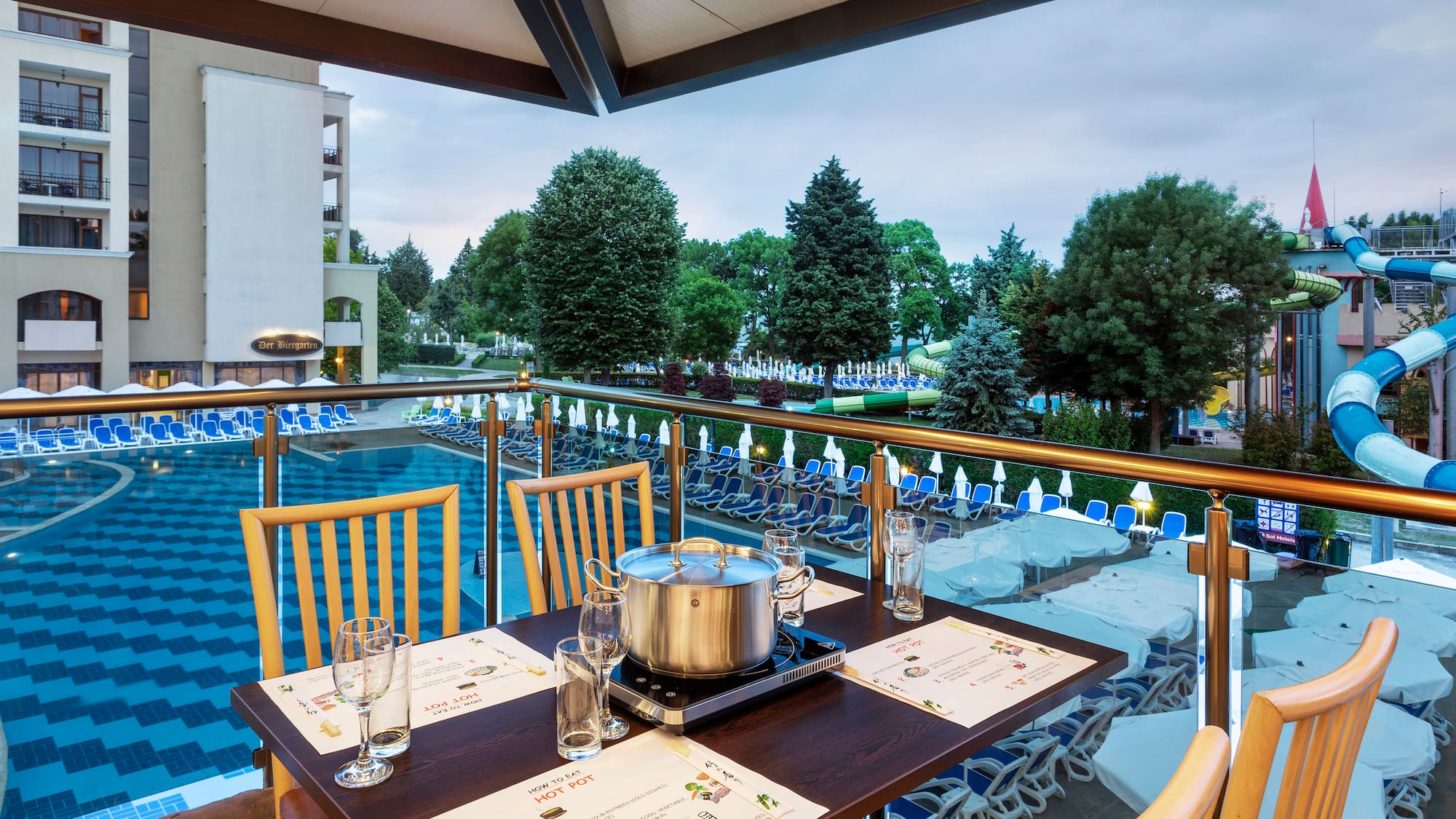 a table with chairs and a pot on it by a pool