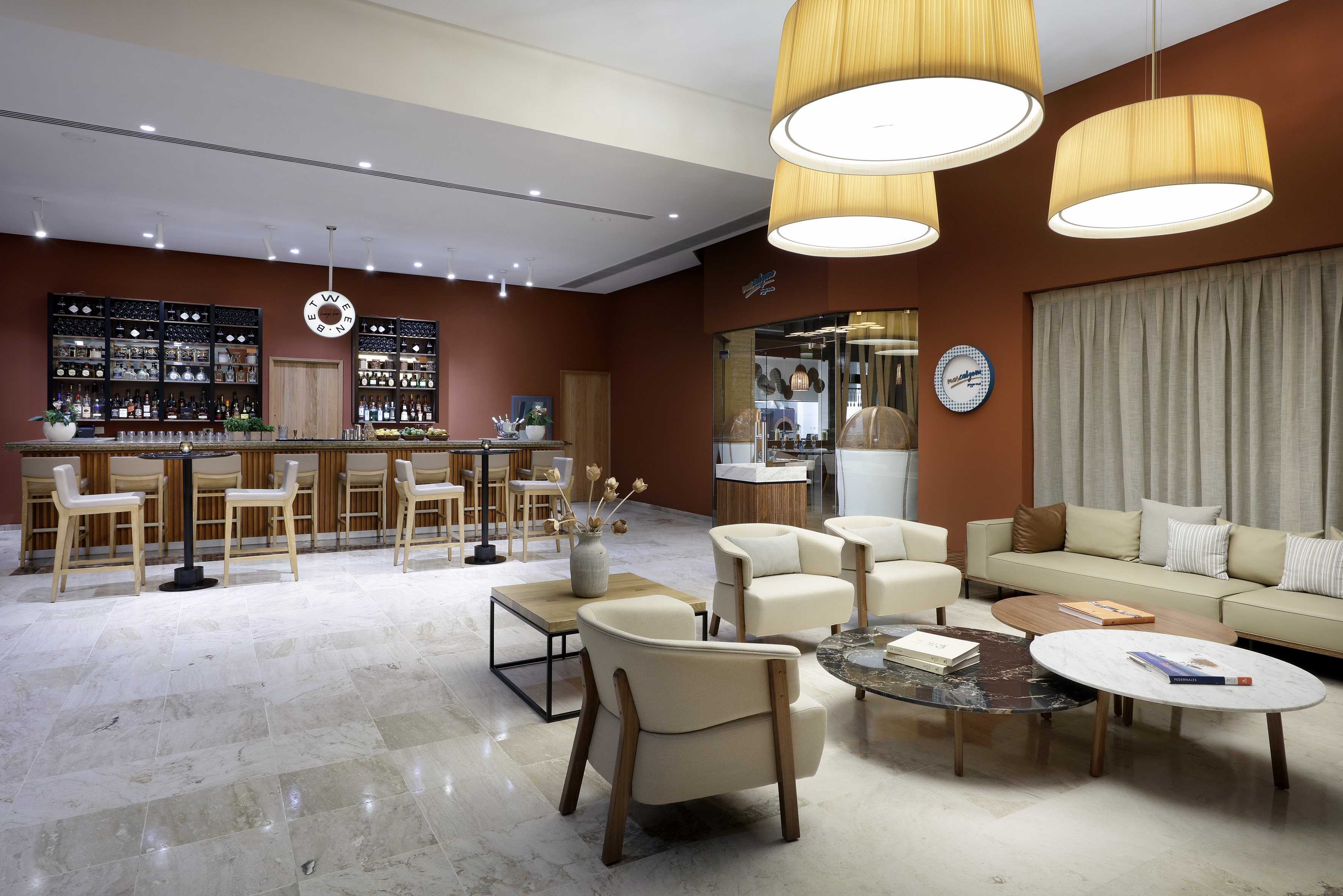 Elegant hotel bar and lounge with modern seating, full bar, and warm decor.