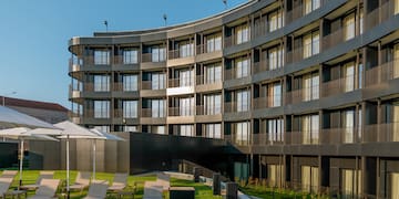 a pool with chairs and a building in the background