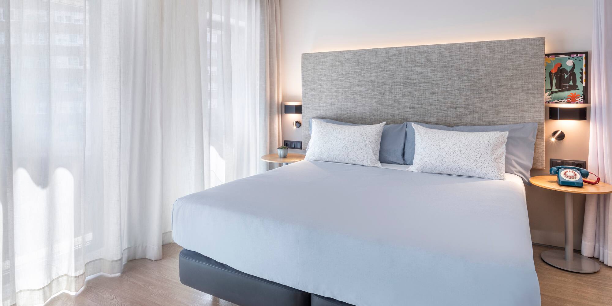 a bed with white sheets and pillows