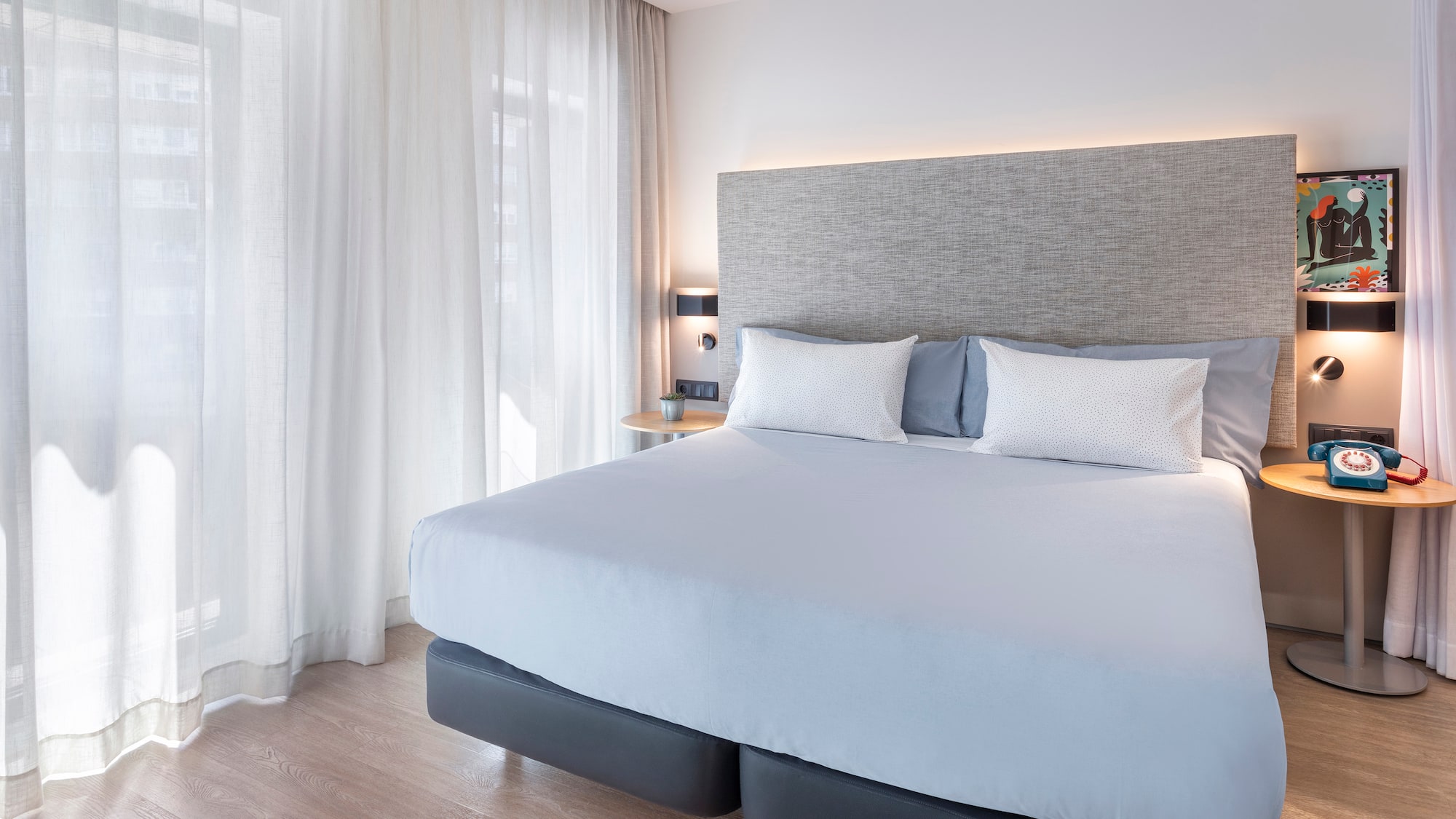 a bed with white sheets and pillows