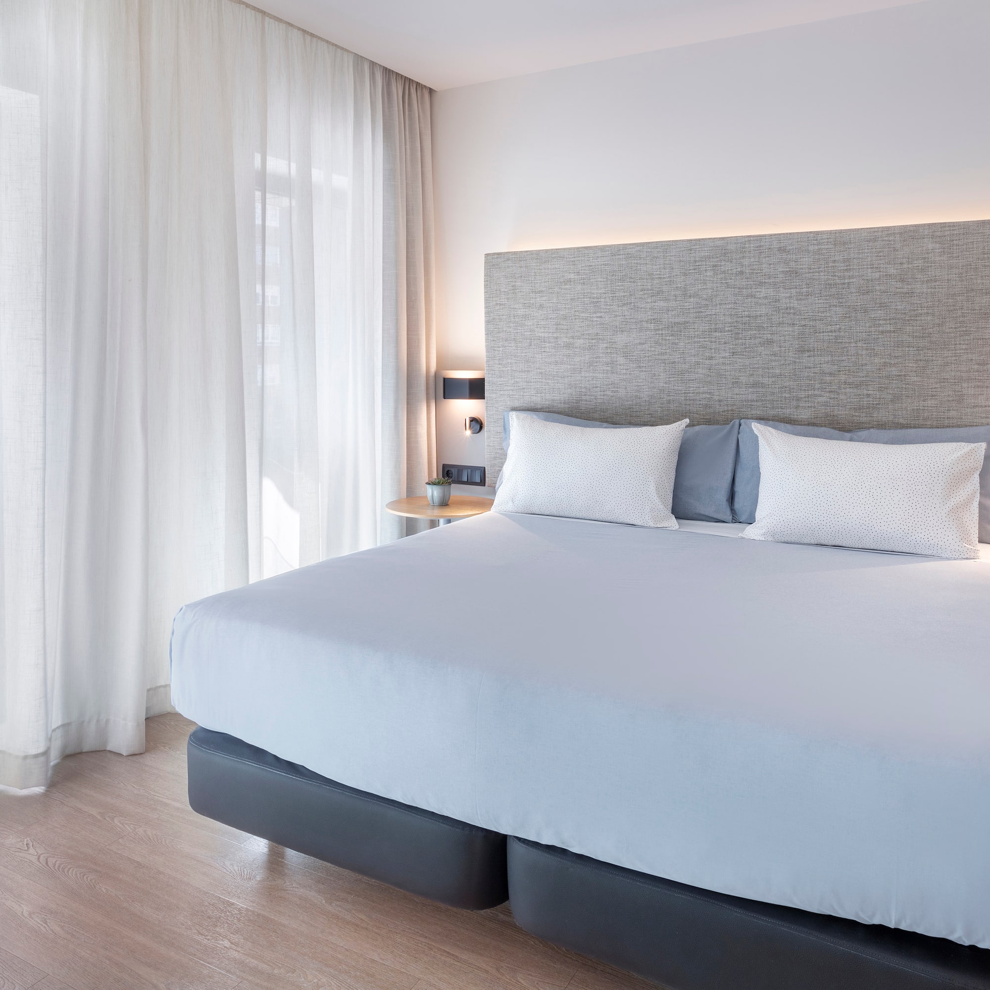 a bed with white sheets and pillows