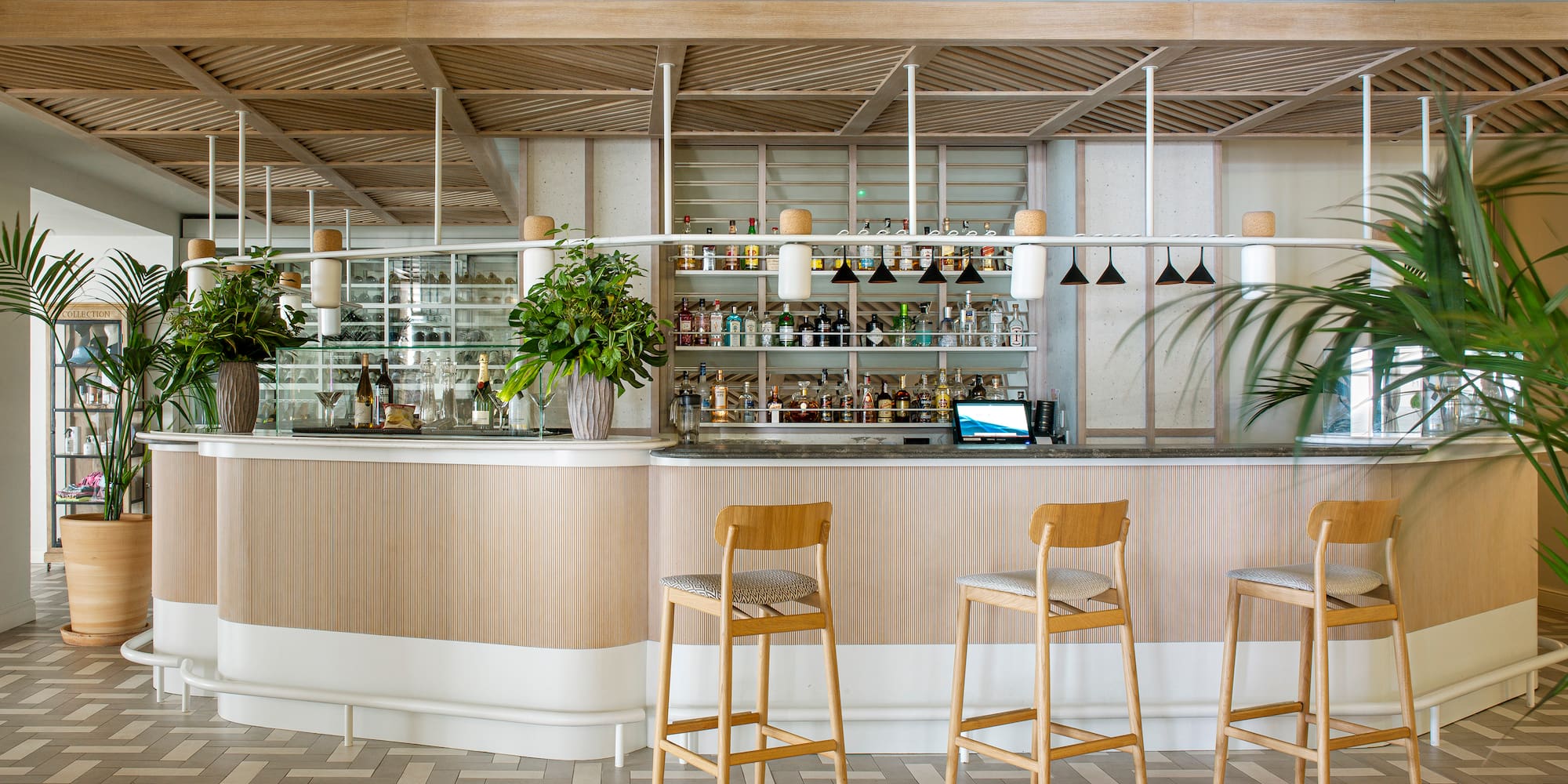 a bar with chairs and plants