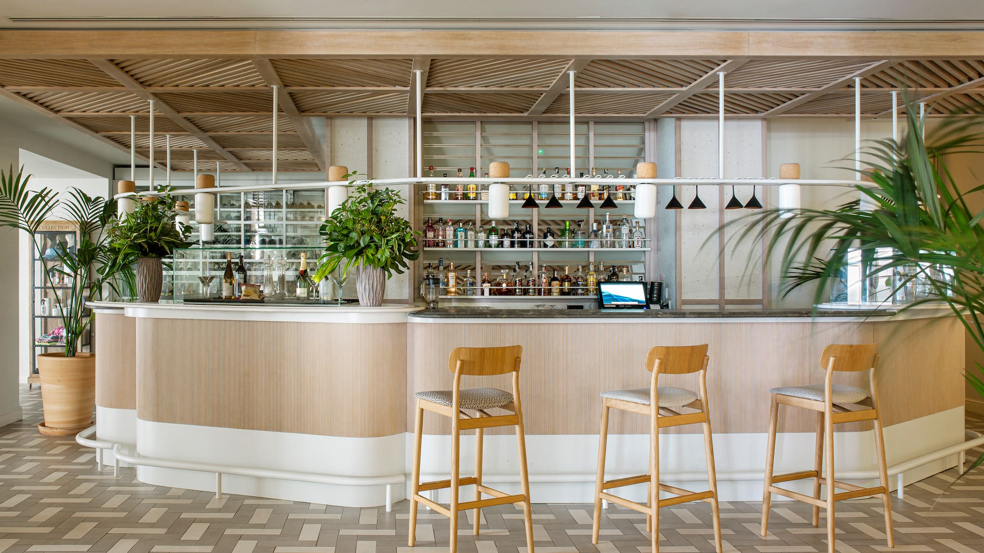 a bar with chairs and plants
