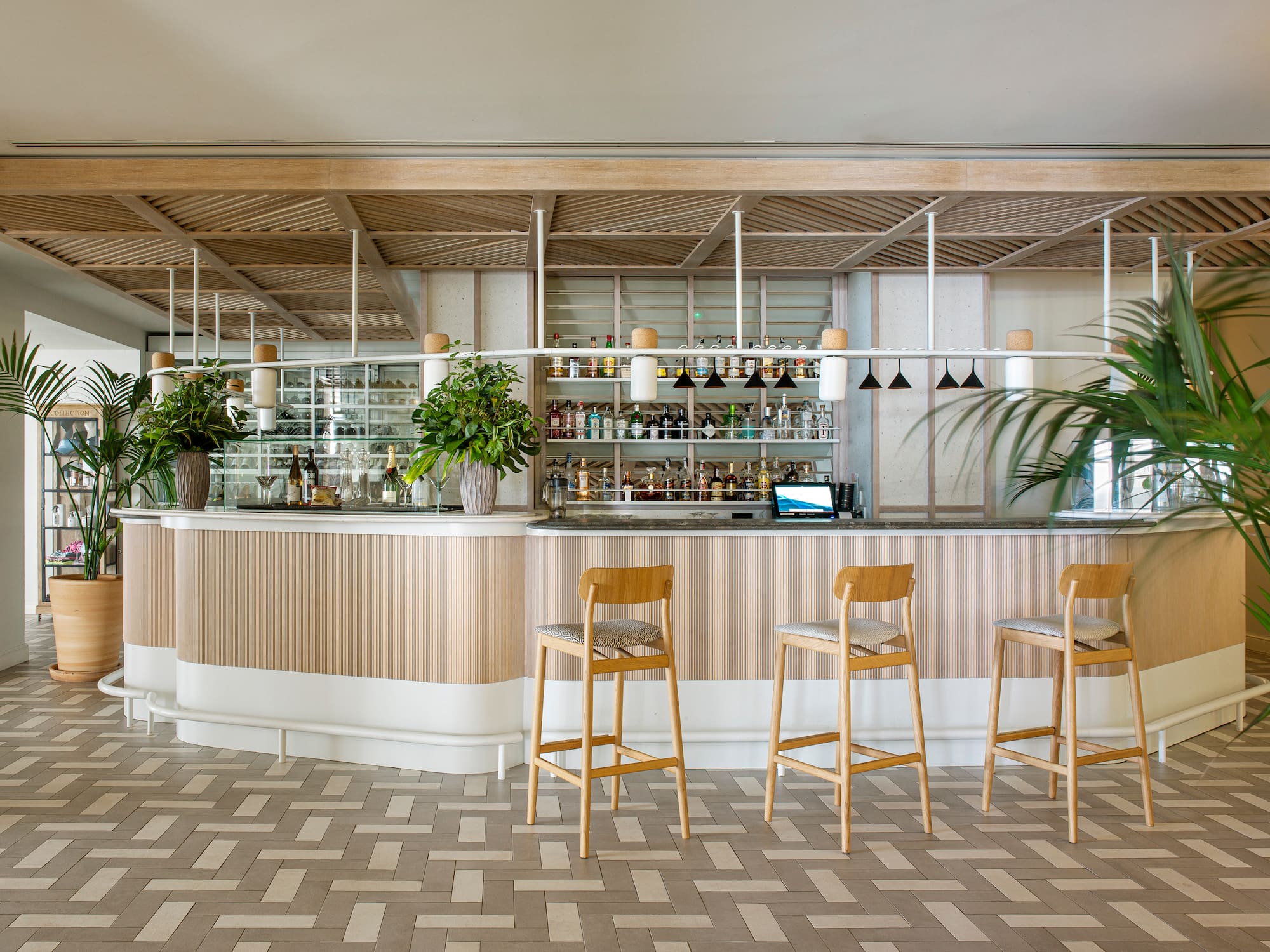 a bar with chairs and plants