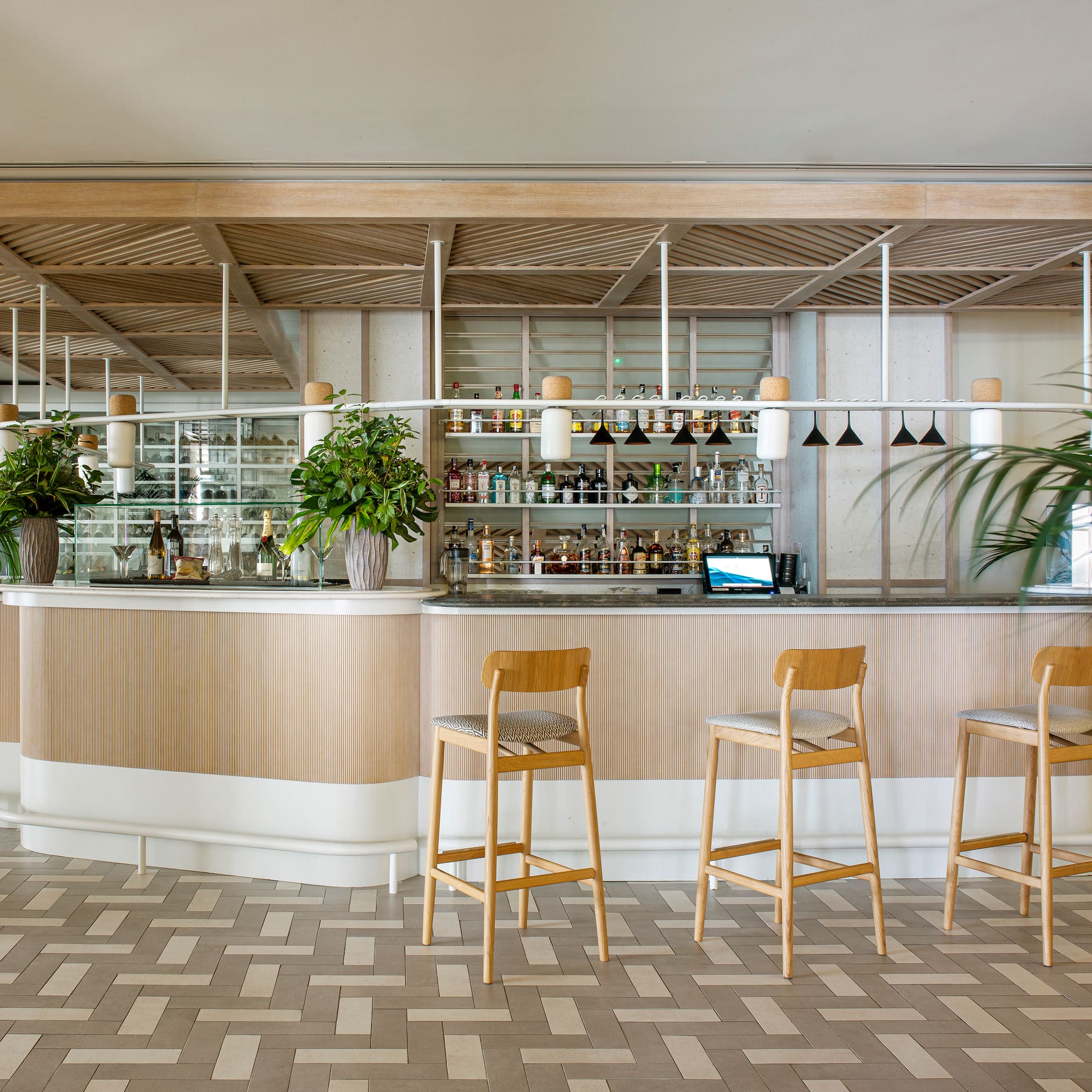 a bar with chairs and plants