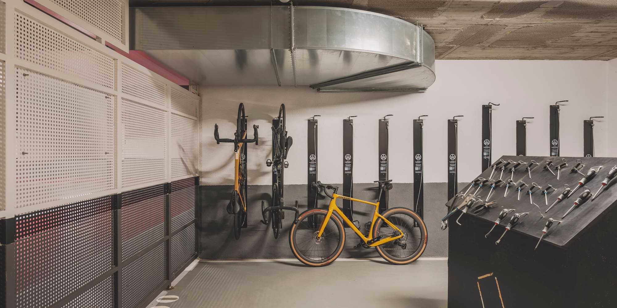 Bike storage with yellow gravel bike, wall racks, and repair tools.