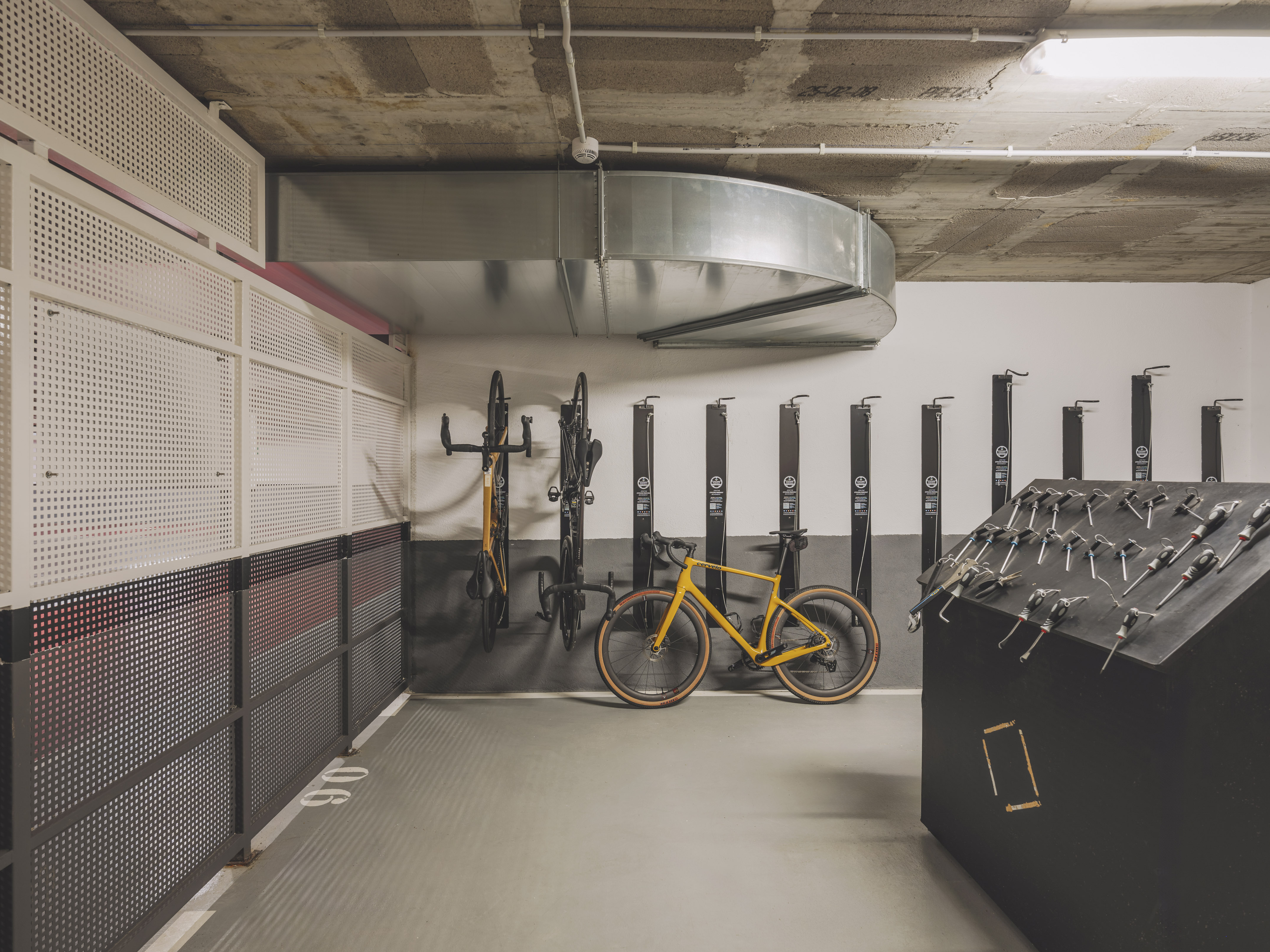 Bike storage with yellow gravel bike, wall racks, and repair tools.