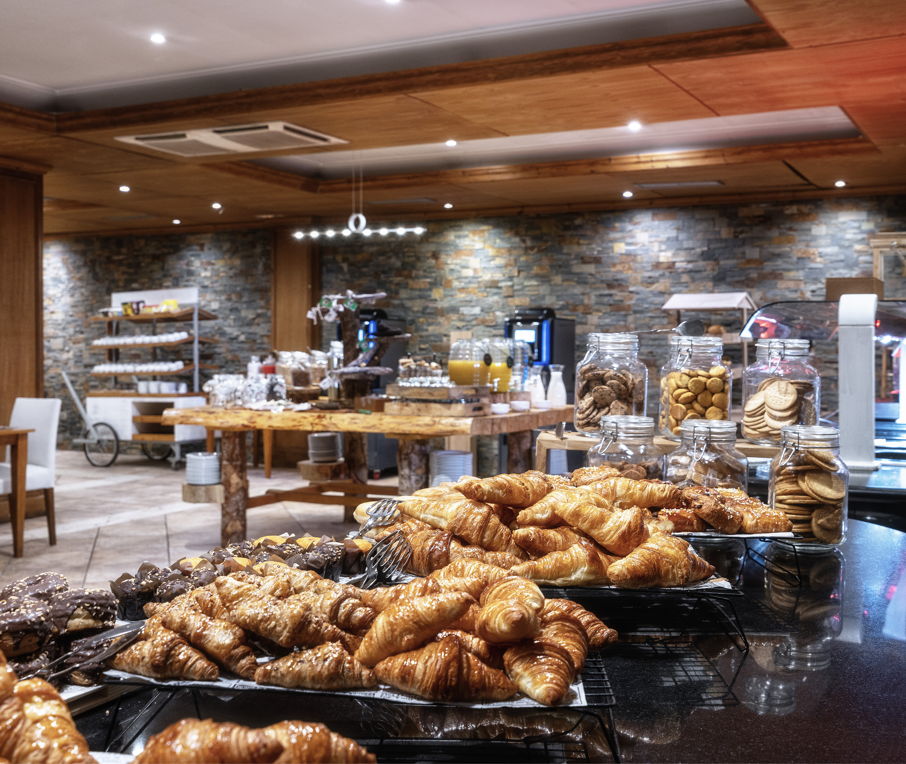 Hotel breakfast buffet with golden croissants, pastries, and cookie jars.