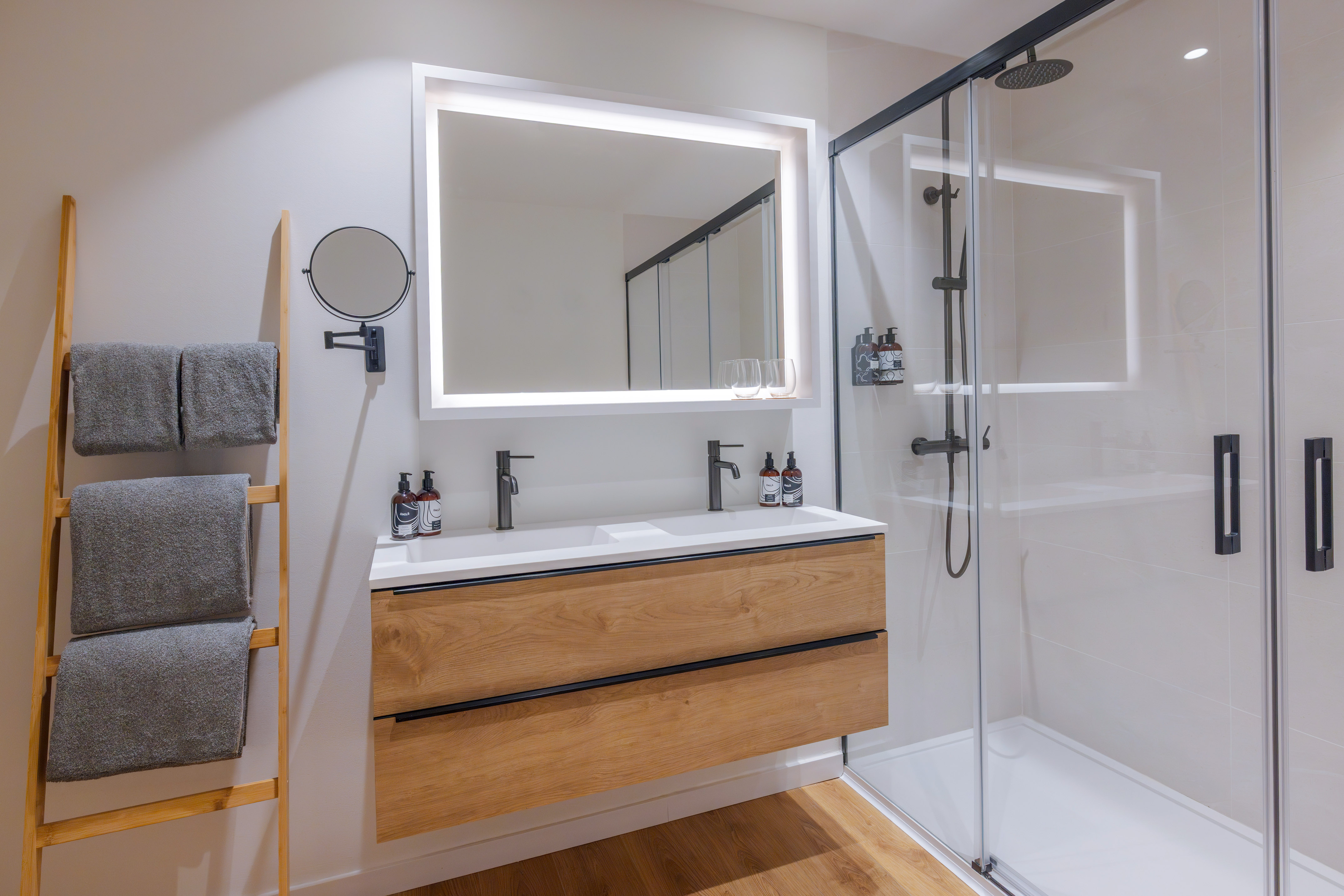 Baño moderno. Lavabo doble madera, espejo LED, ducha cristal y toallero.