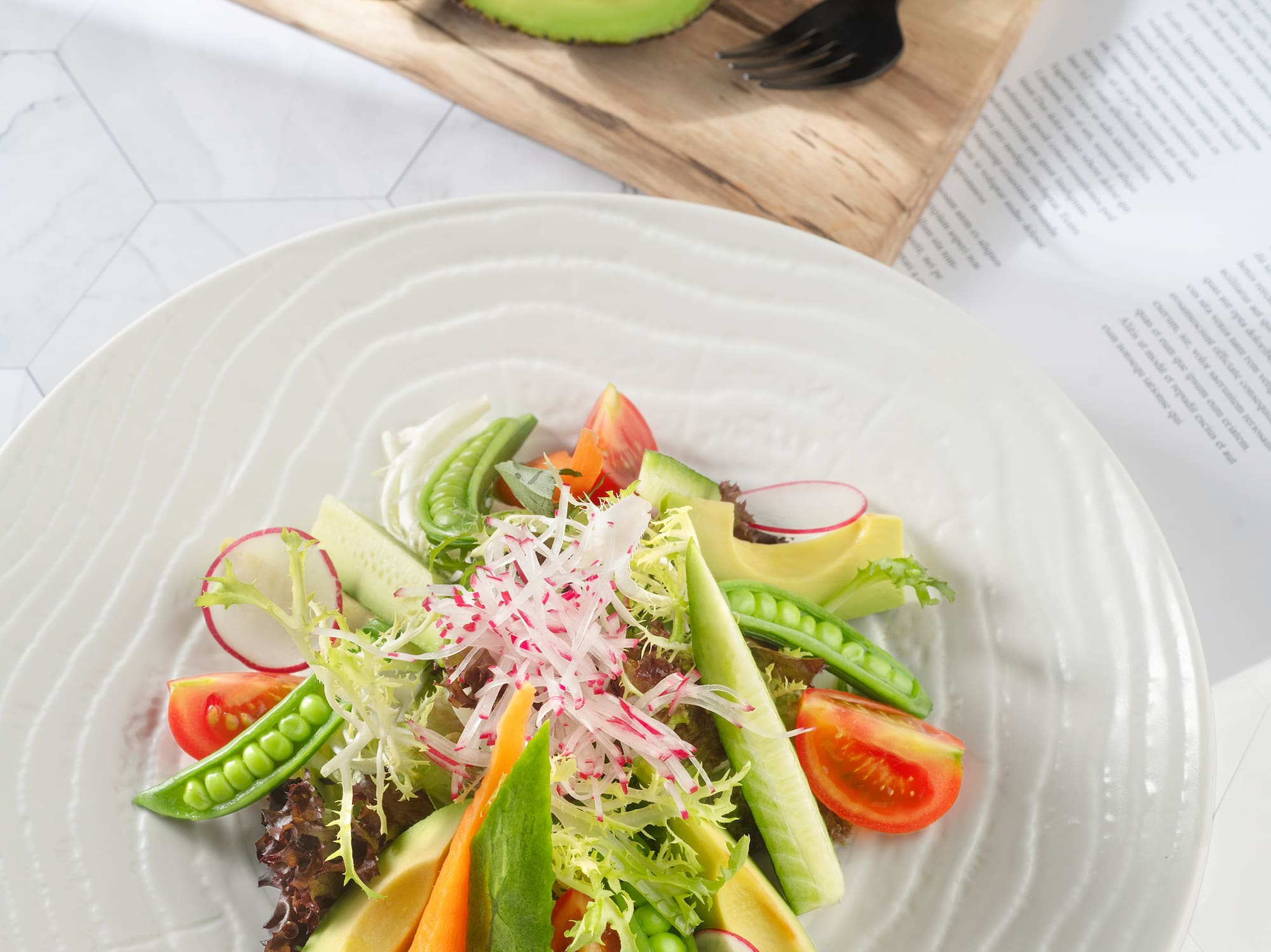 a plate of salad with avocado and vegetables