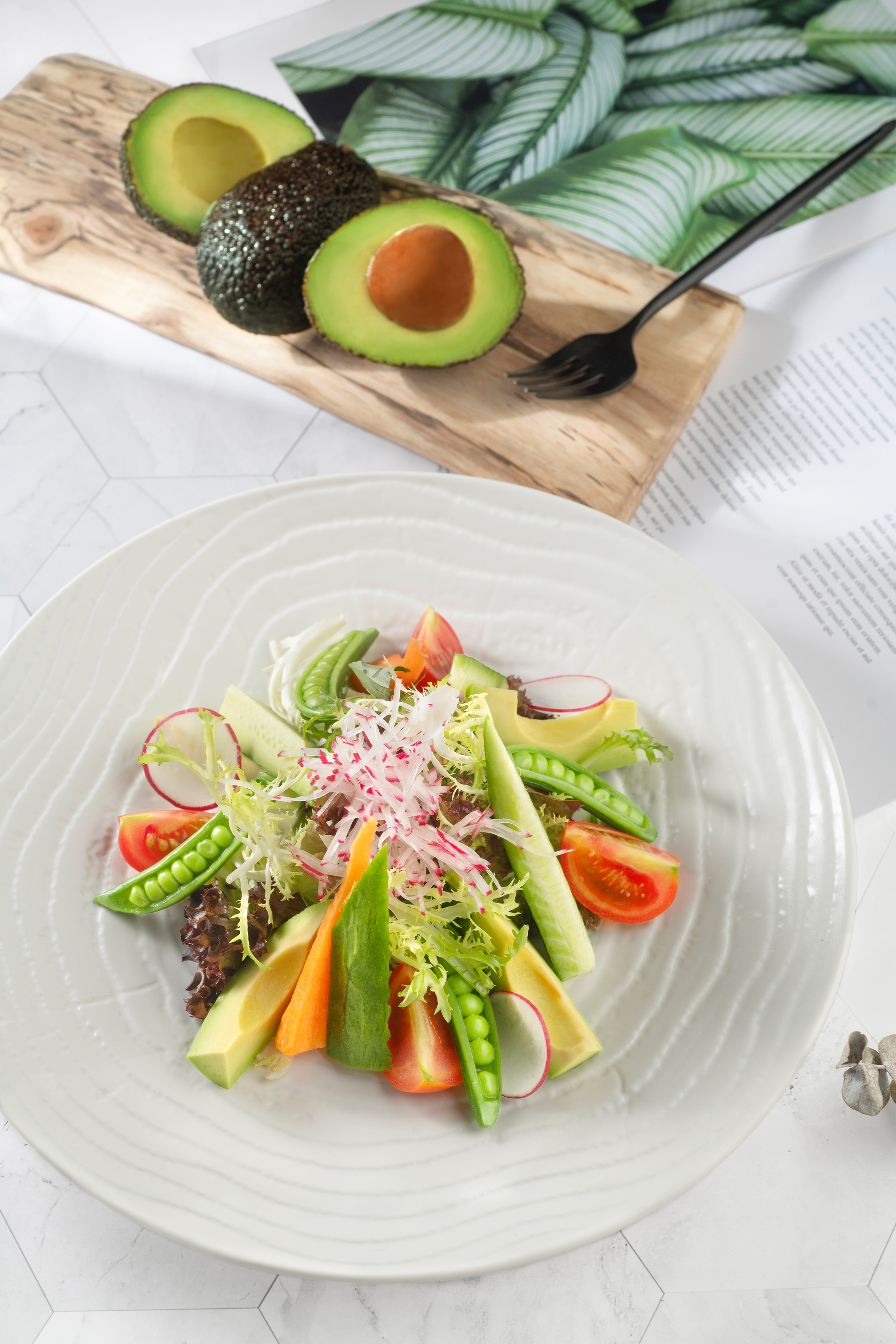 a plate of salad with avocado and vegetables
