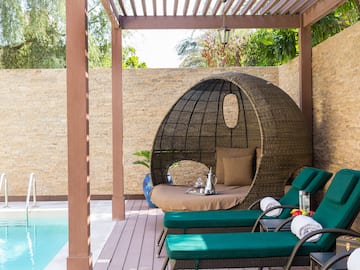a patio with a round chair and a pool