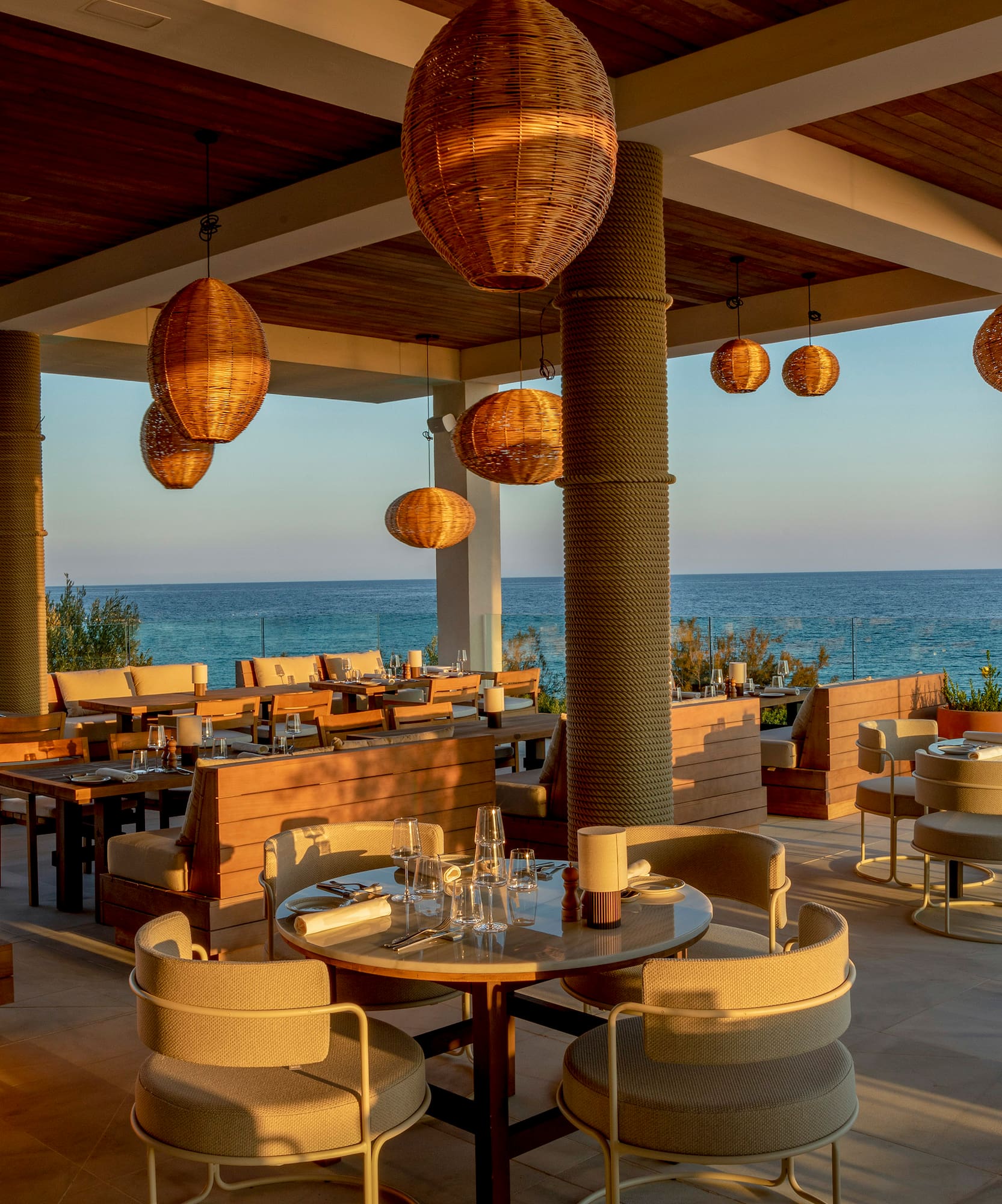 a restaurant with tables and chairs and a view of the ocean