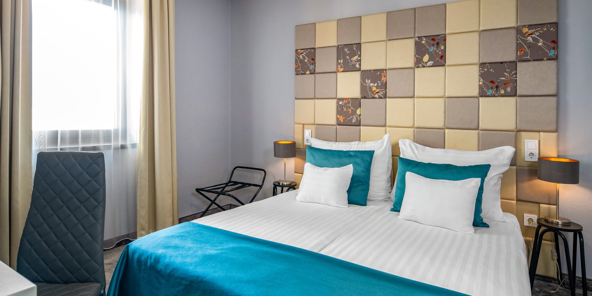 a bed with a blue blanket and a lamp in a room